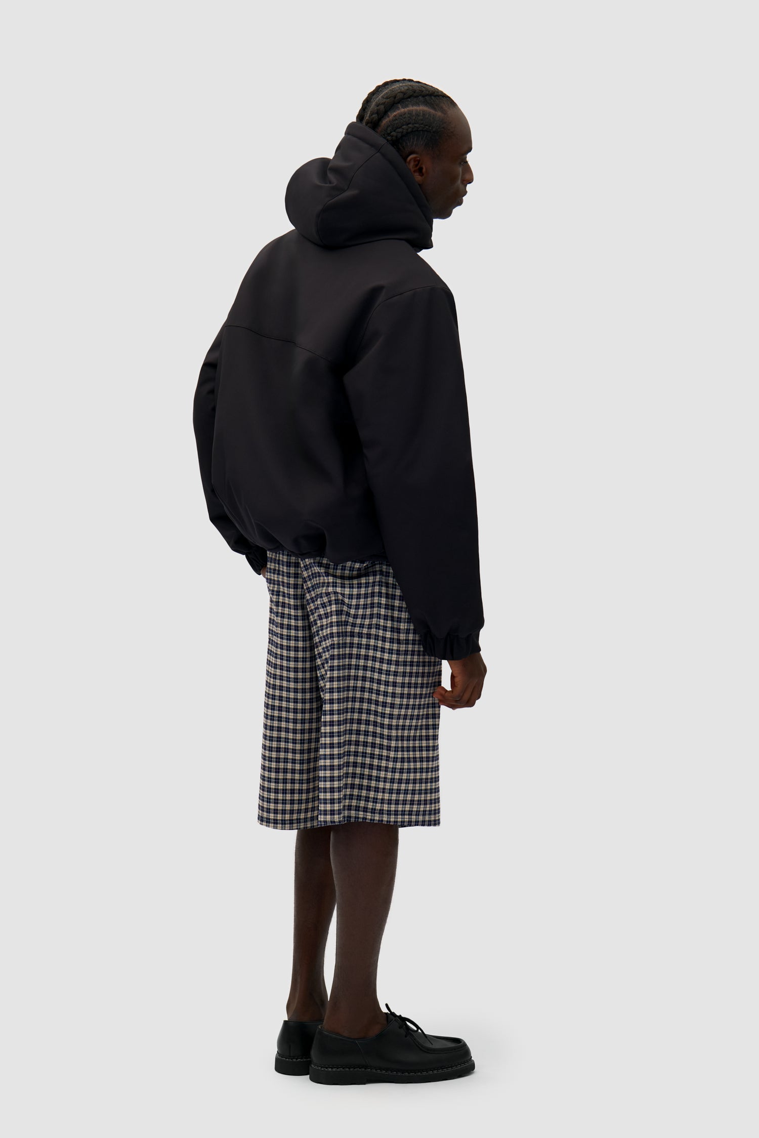 Technical Anorak in Black worn by a model, full-body back view