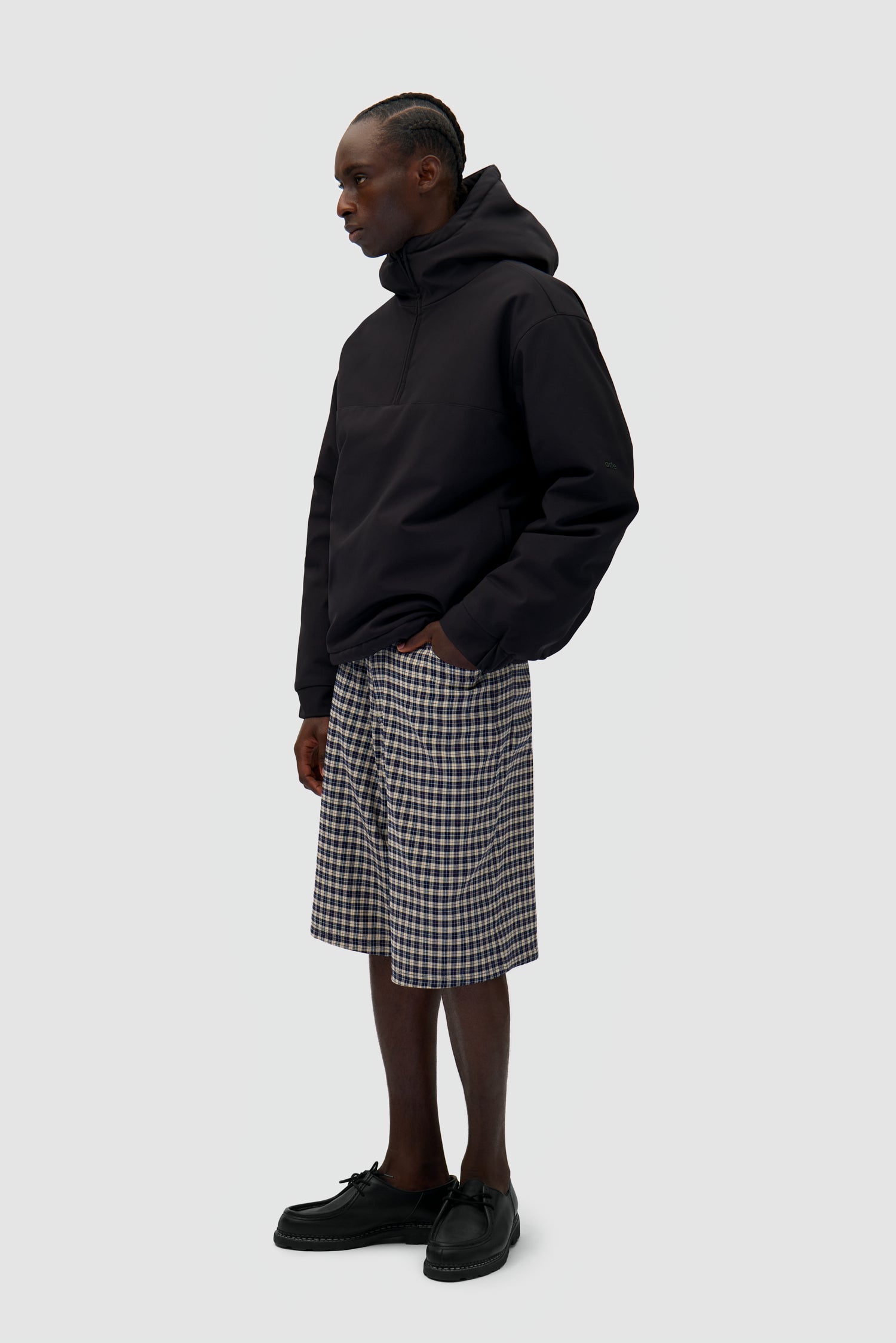 Technical Anorak in Black worn by a model, full-body side view