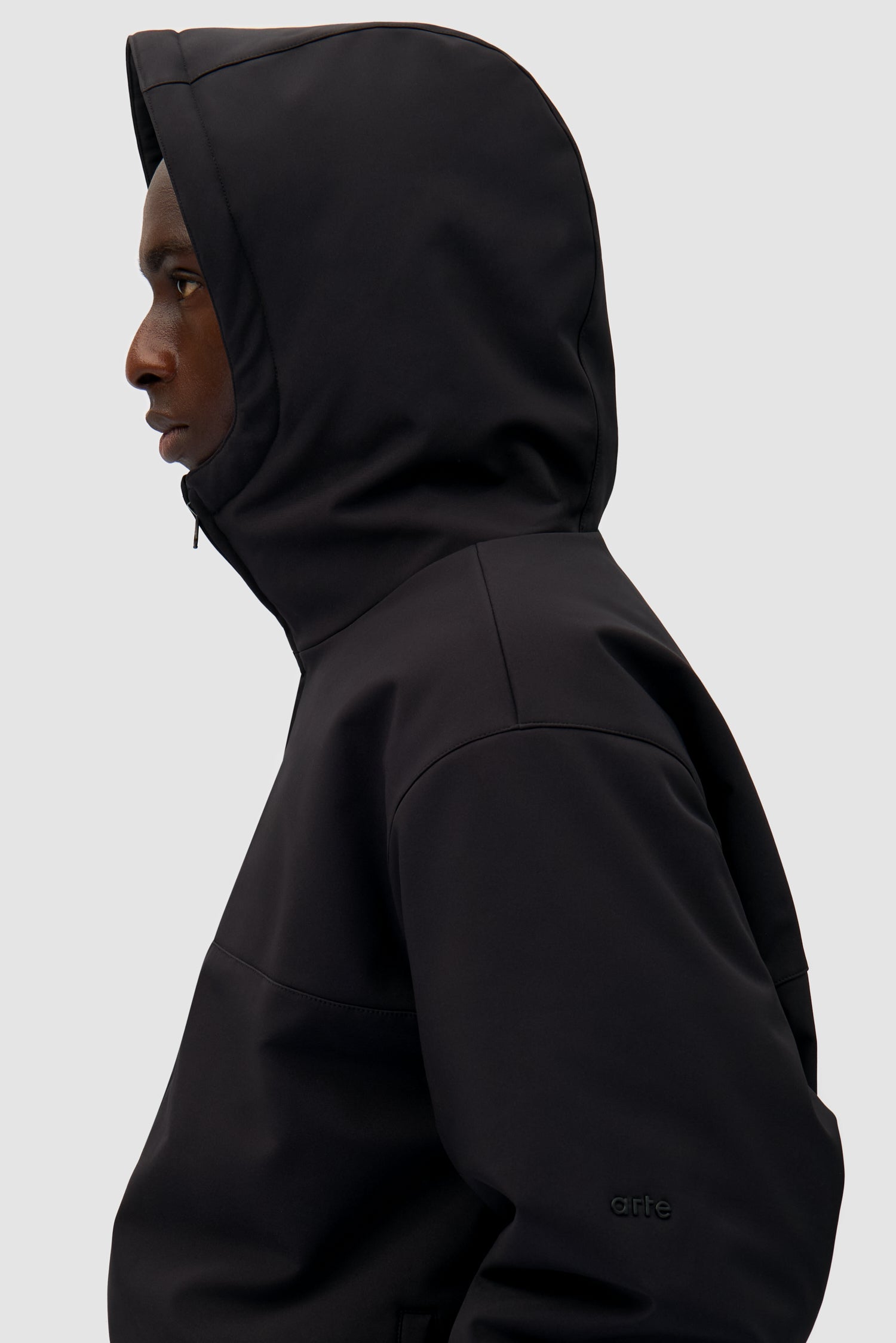 Technical Anorak in Black worn by a model, half-body detailed view