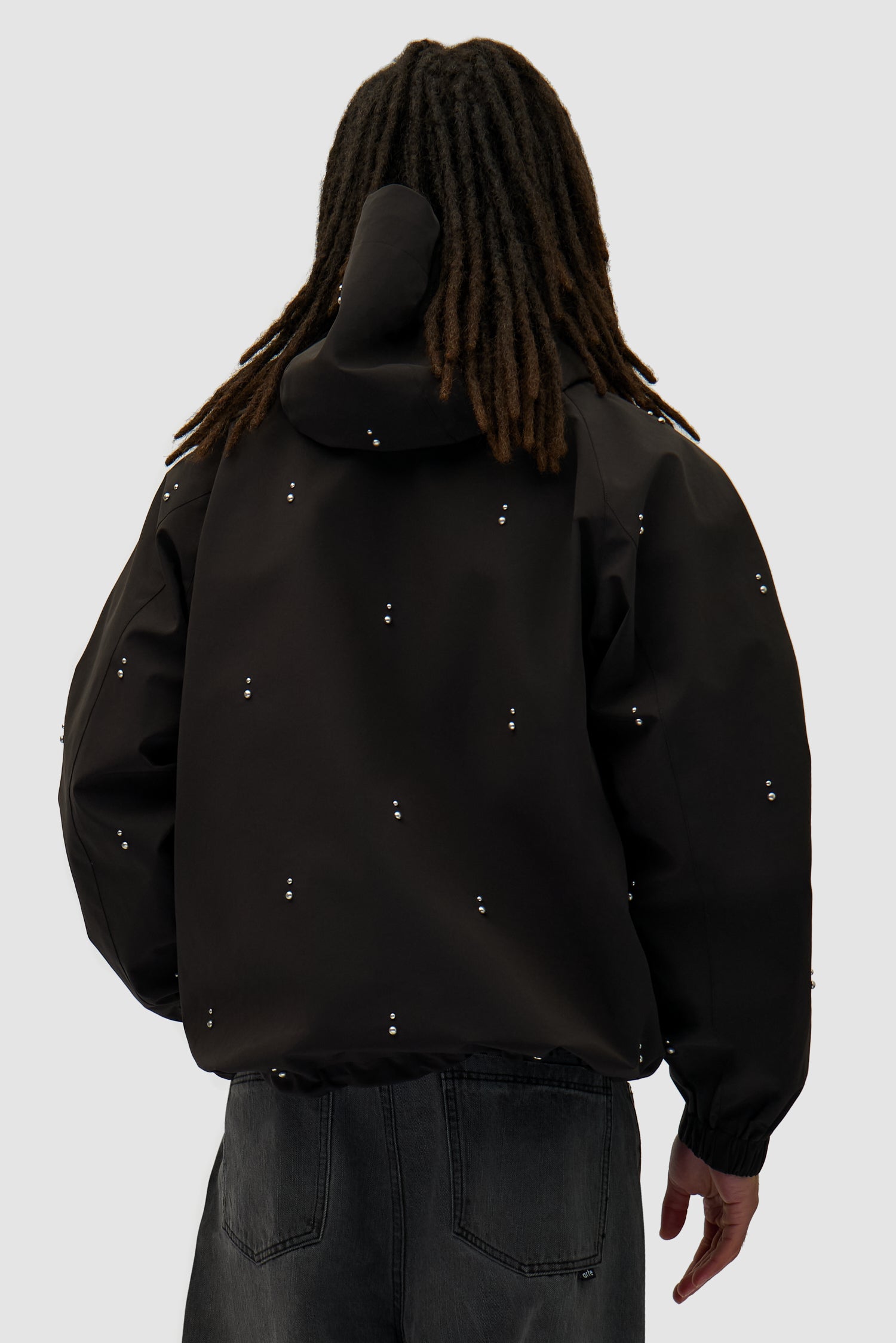 Technical Revits Jacket in Black worn by a model, half-body back view