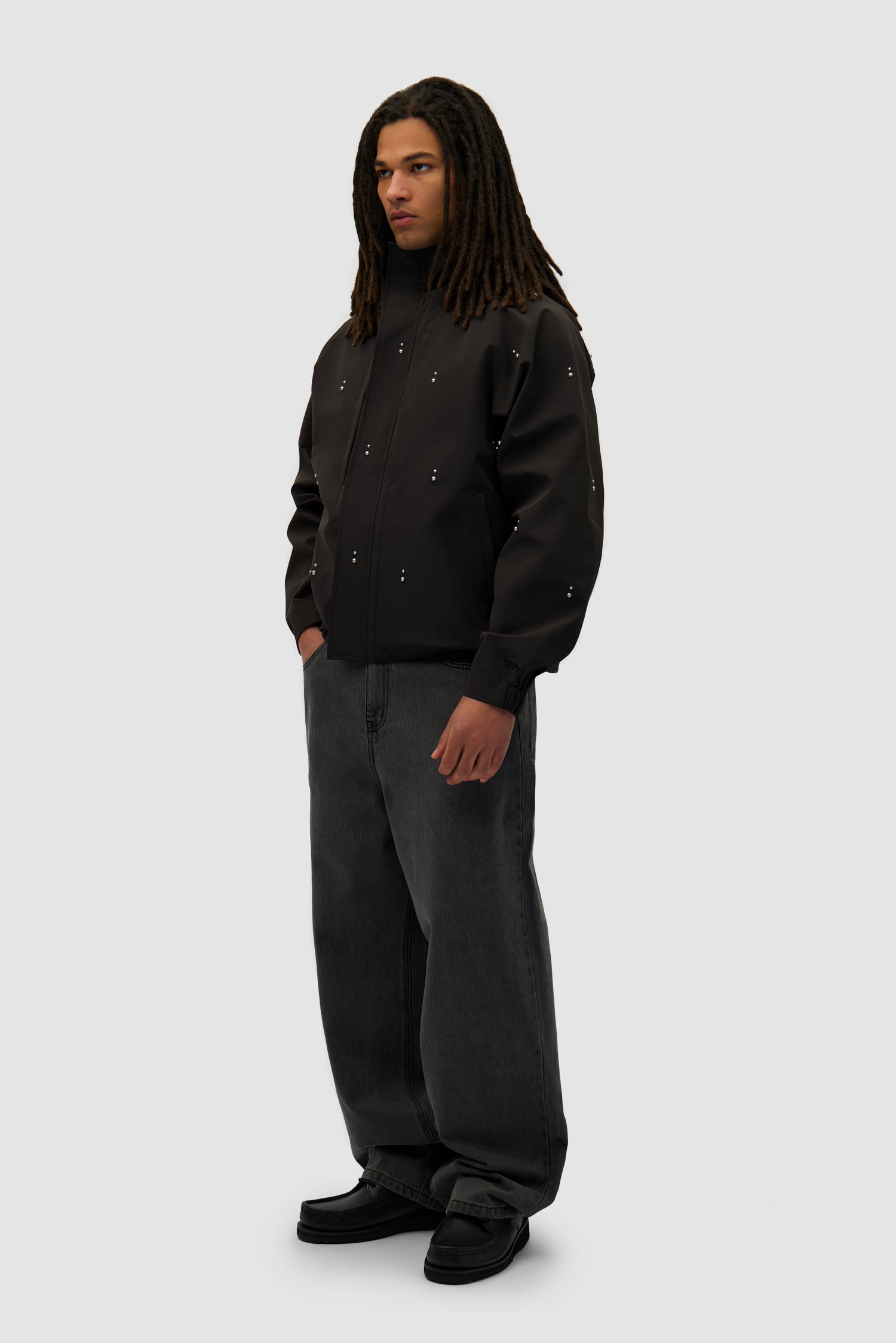 Technical Revits Jacket in Black worn by a model, full-body side view