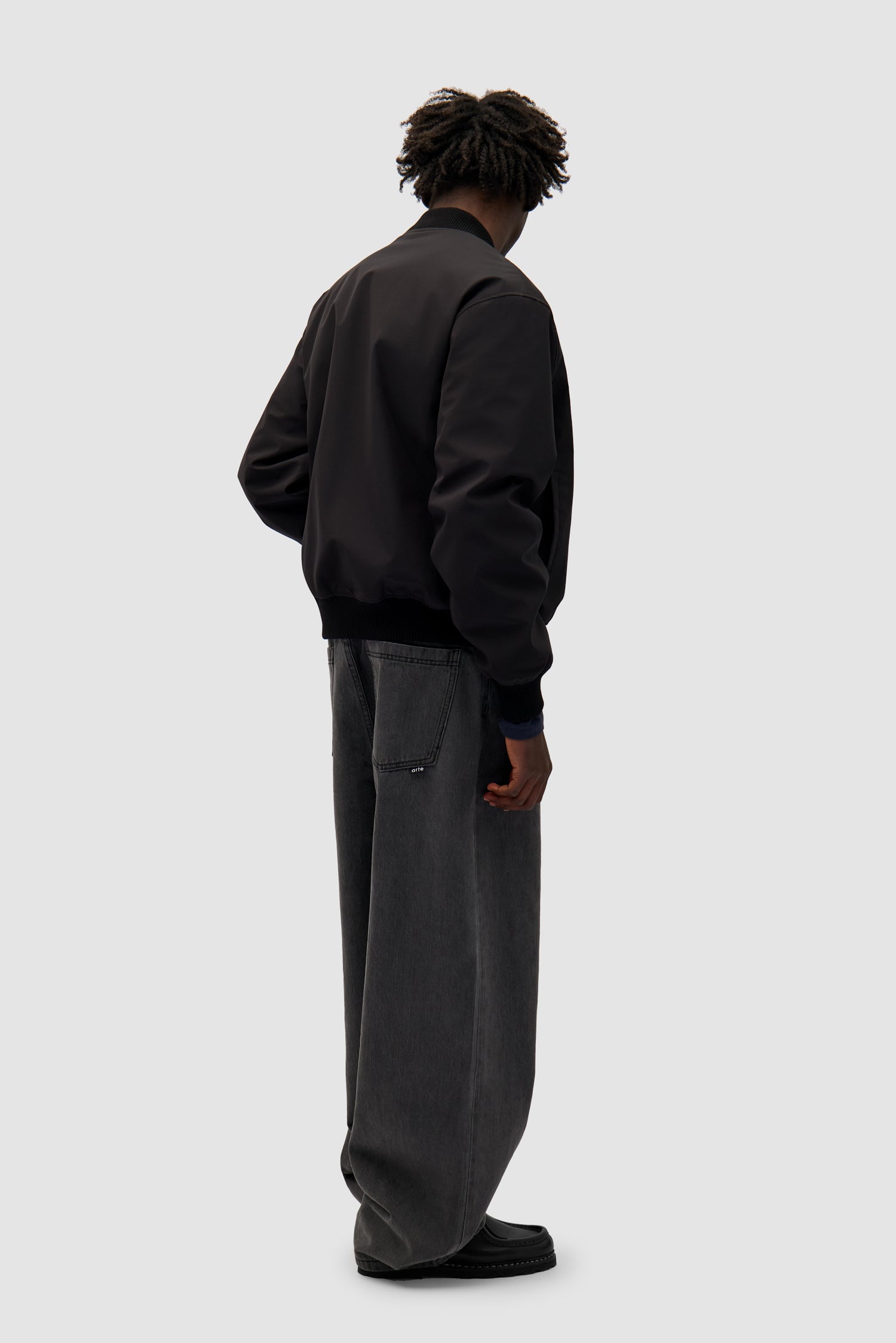 Logo Bird Bomber Jacket in Black worn by a model, full-body back view