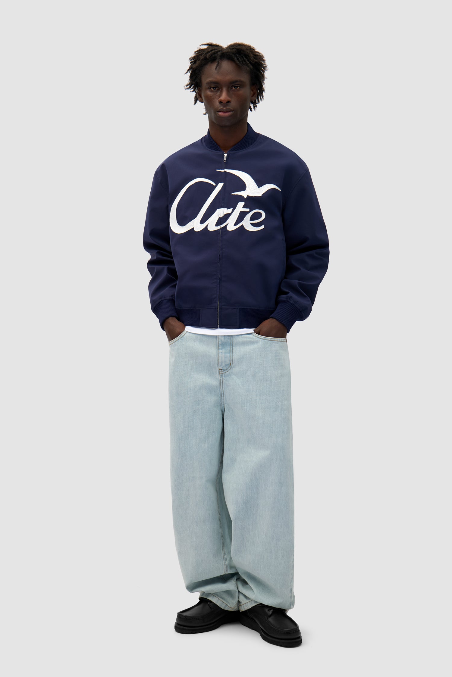 Logo Bird Bomber Jacket in Navy worn by a model, full-body front view