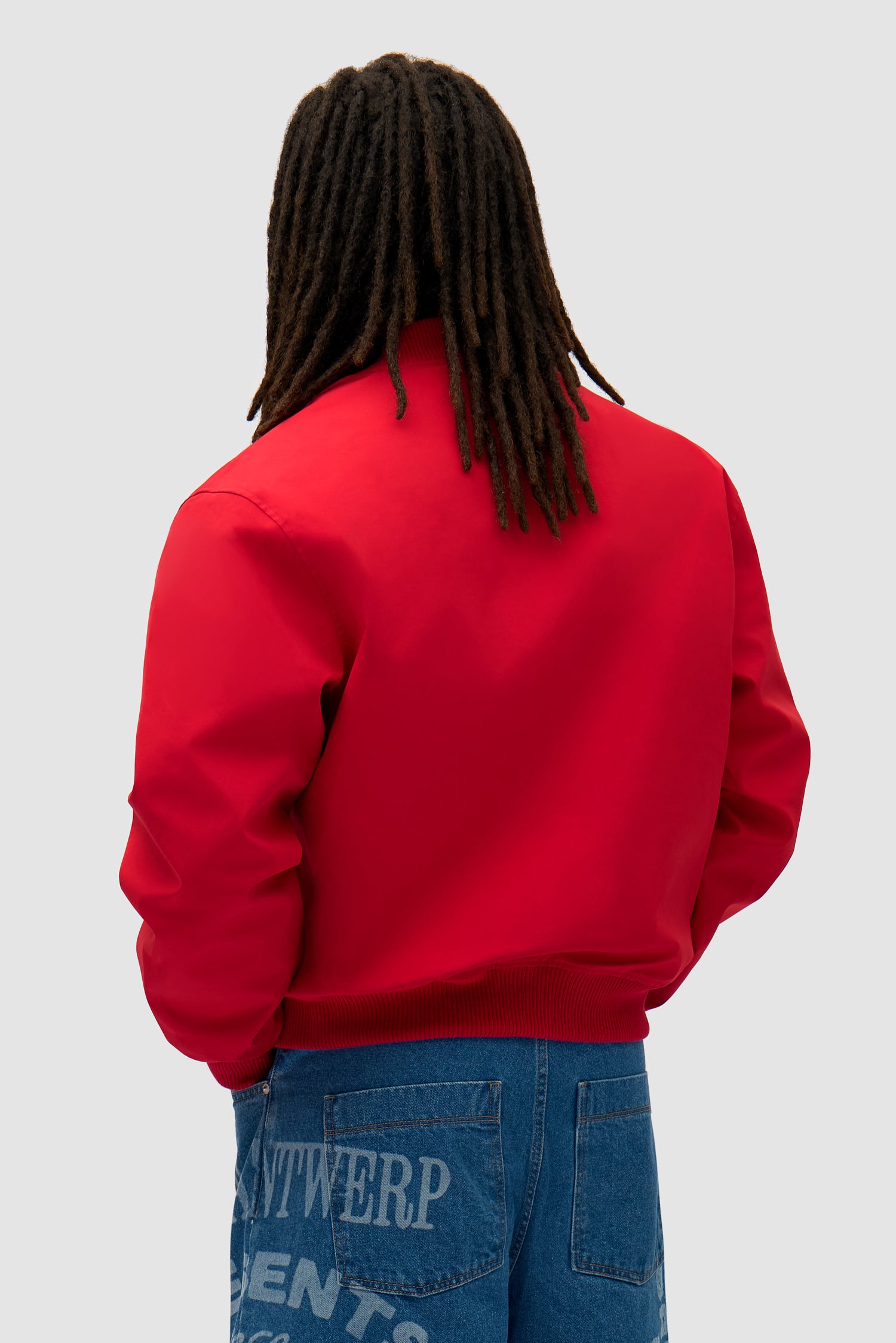 Logo Bird Bomber Jacket in Red worn by a model, half-body back view