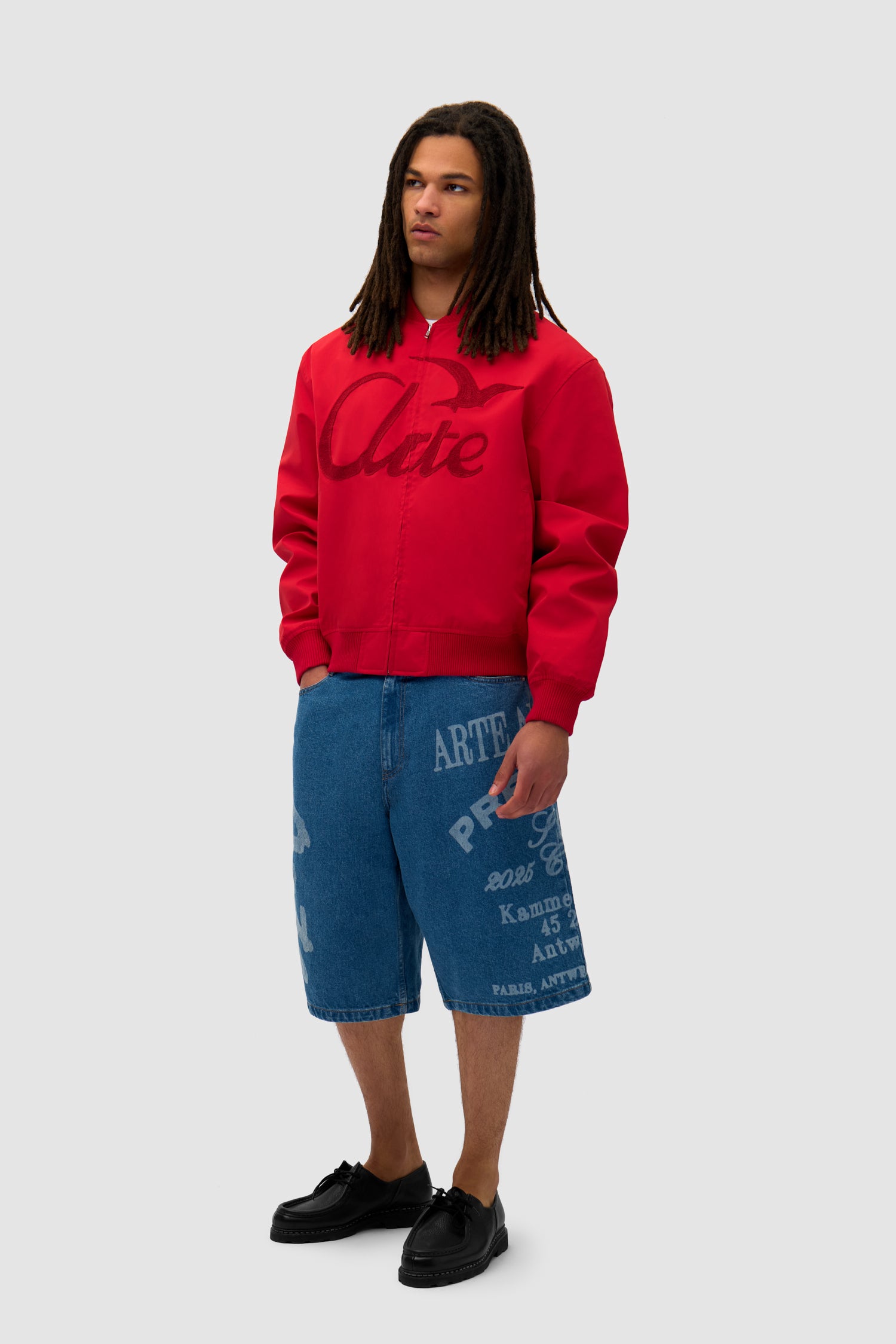 Logo Bird Bomber Jacket in Red worn by a model, full-body side view