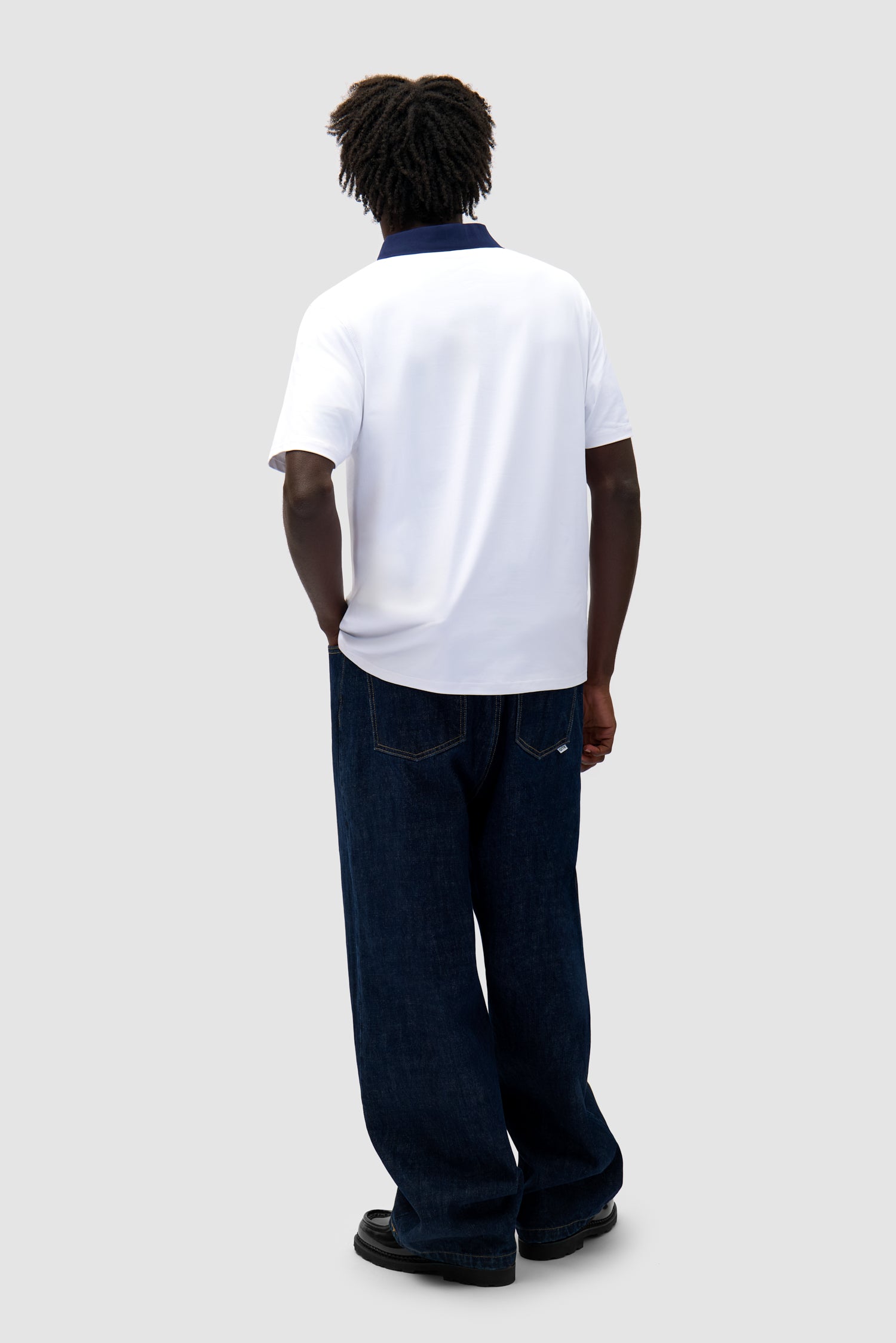 Logo Collar T-shirt in White/Navy worn by a model, full-body side view