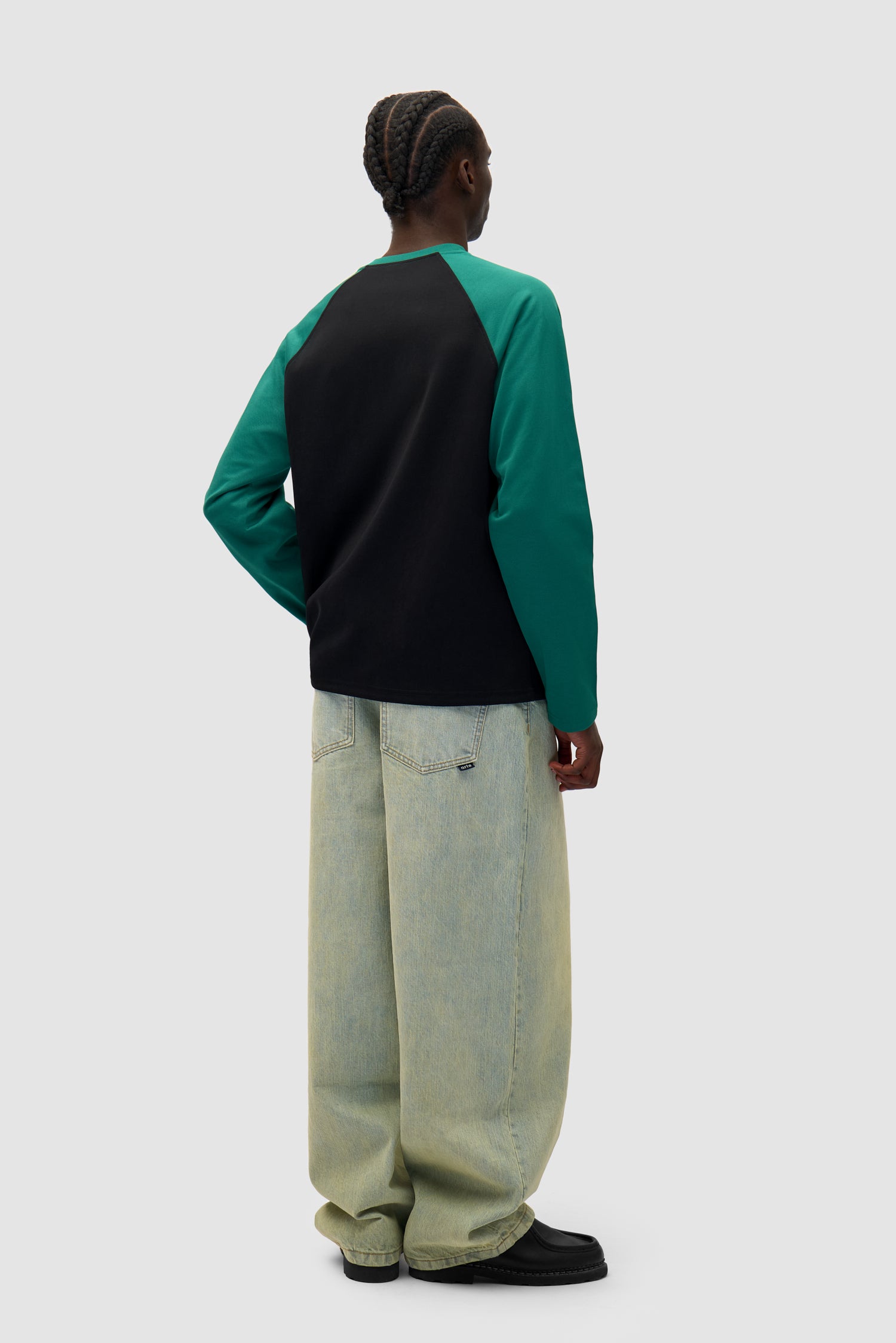 Bird Logo Longsleeve in Green/Black worn by a model, full-body side view