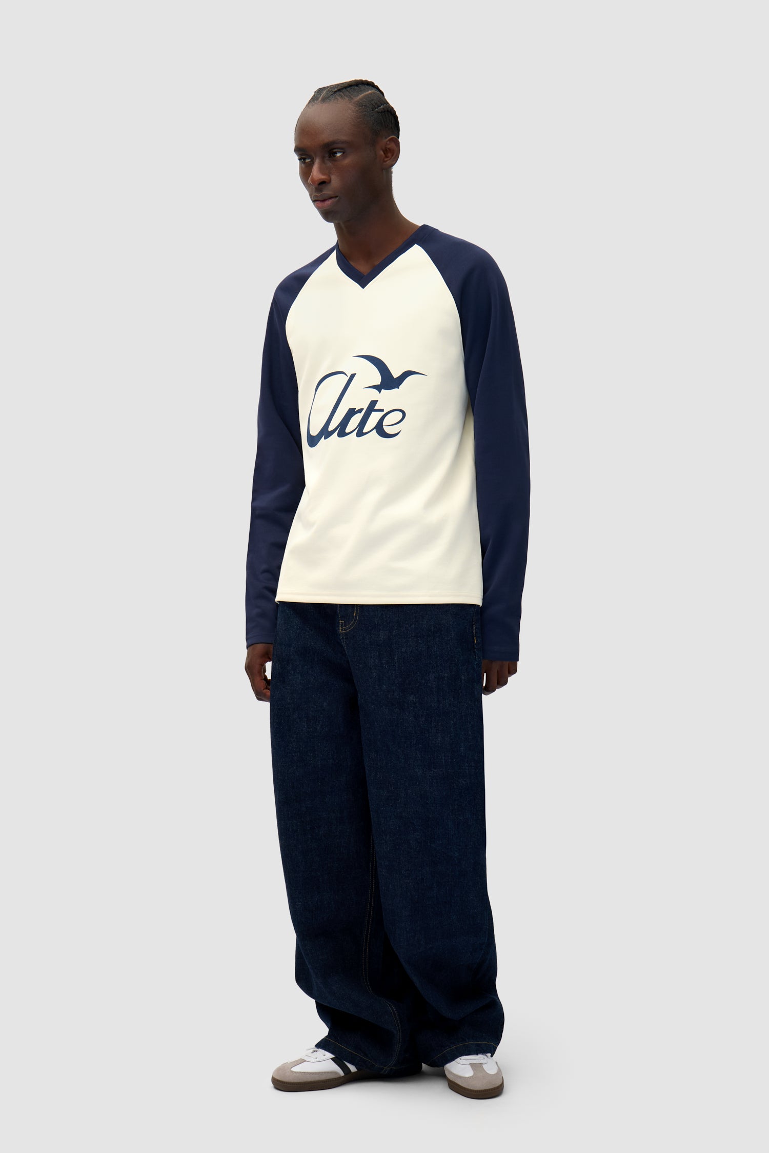 Bird Logo Longsleeve in Navy/Cream worn by a model, full-body side view