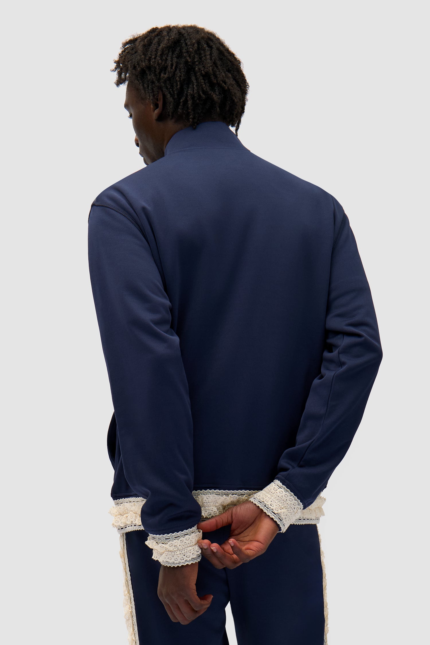 Trim Jacket in Navy worn by a model, half-body back view