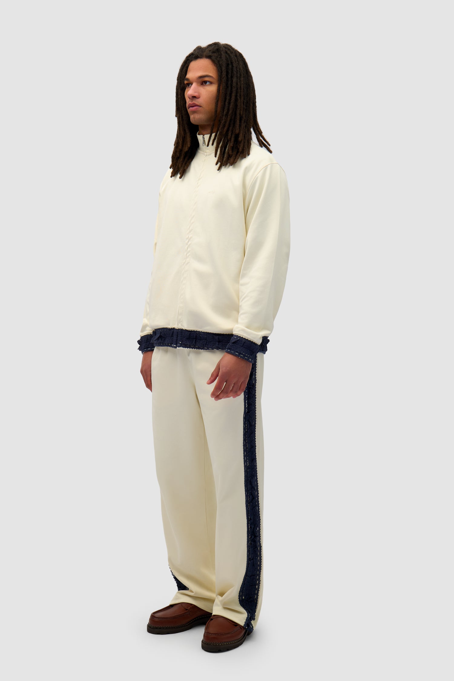 Trim Pants in Cream worn by a model, full-body side view