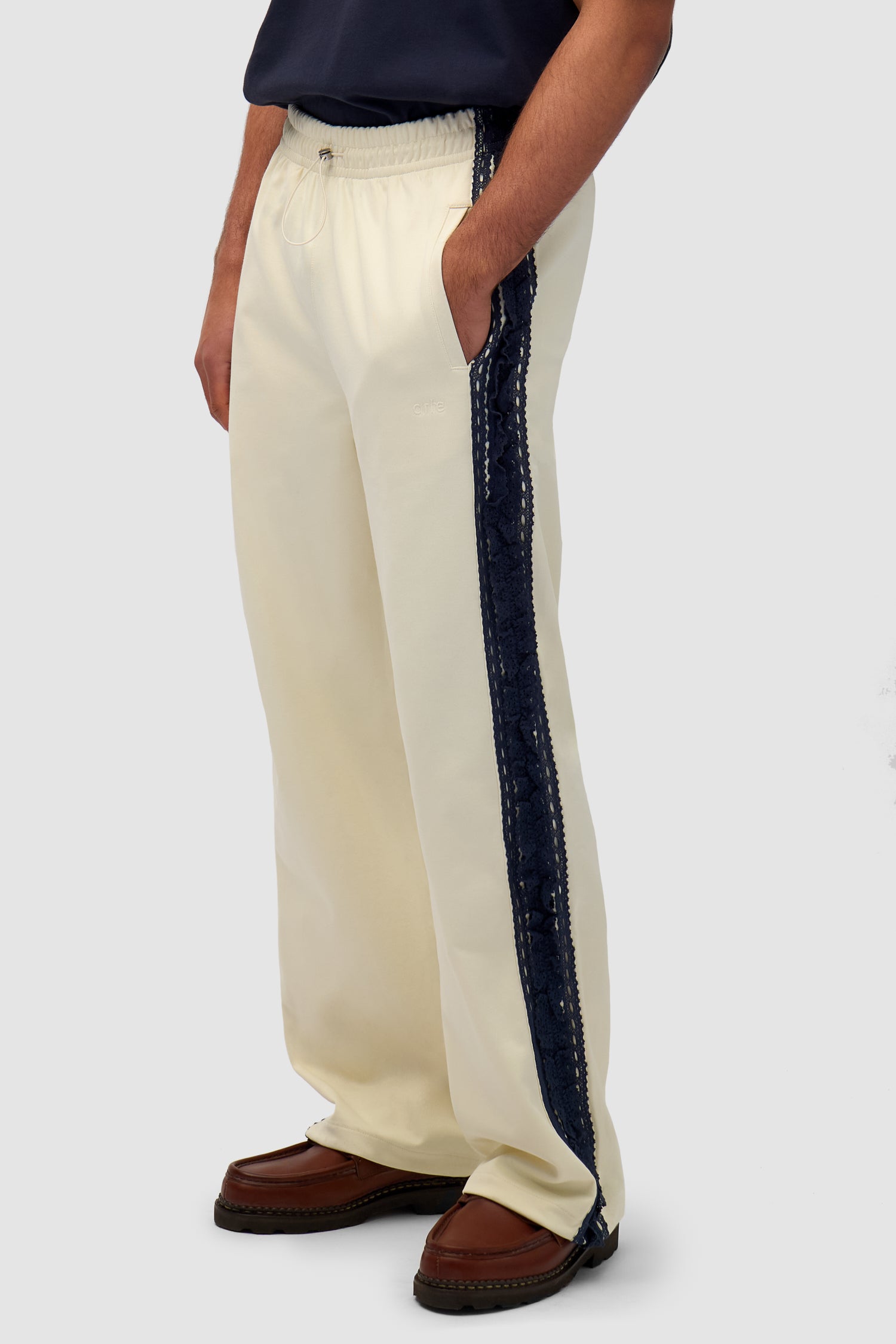 Trim Pants in Cream worn by a model, half-body side view