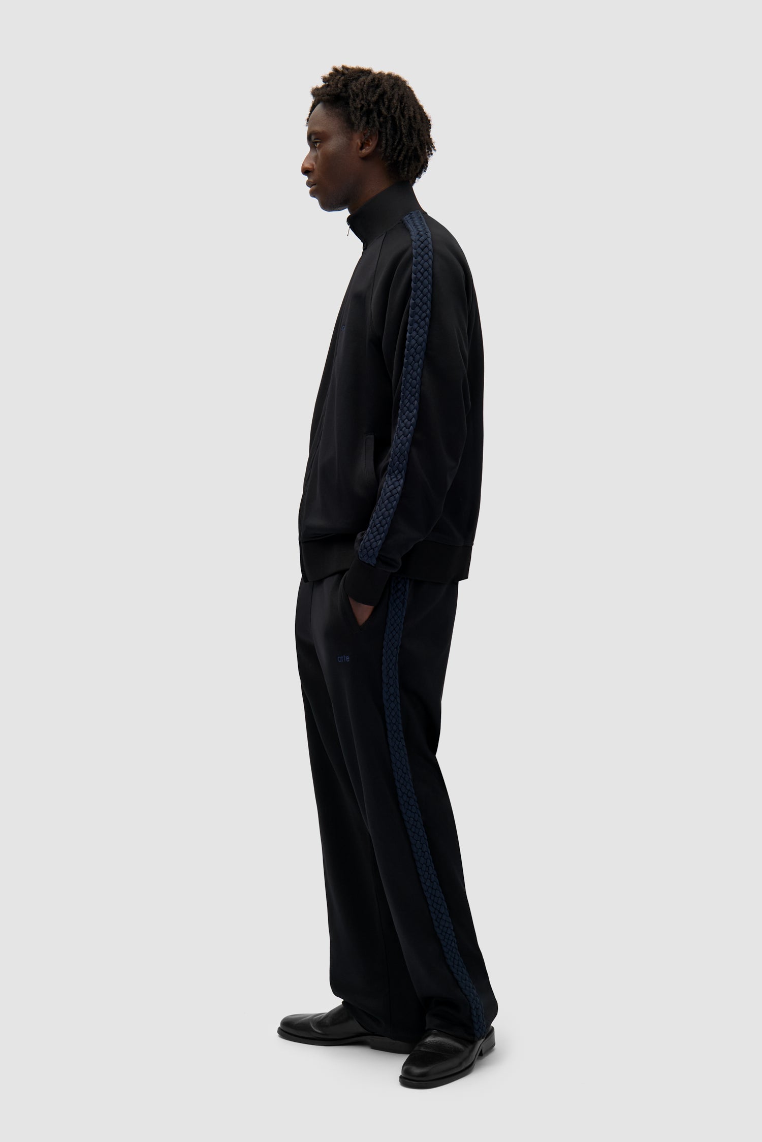 Braid Strip Jacket in Black worn by a model, full-body side view