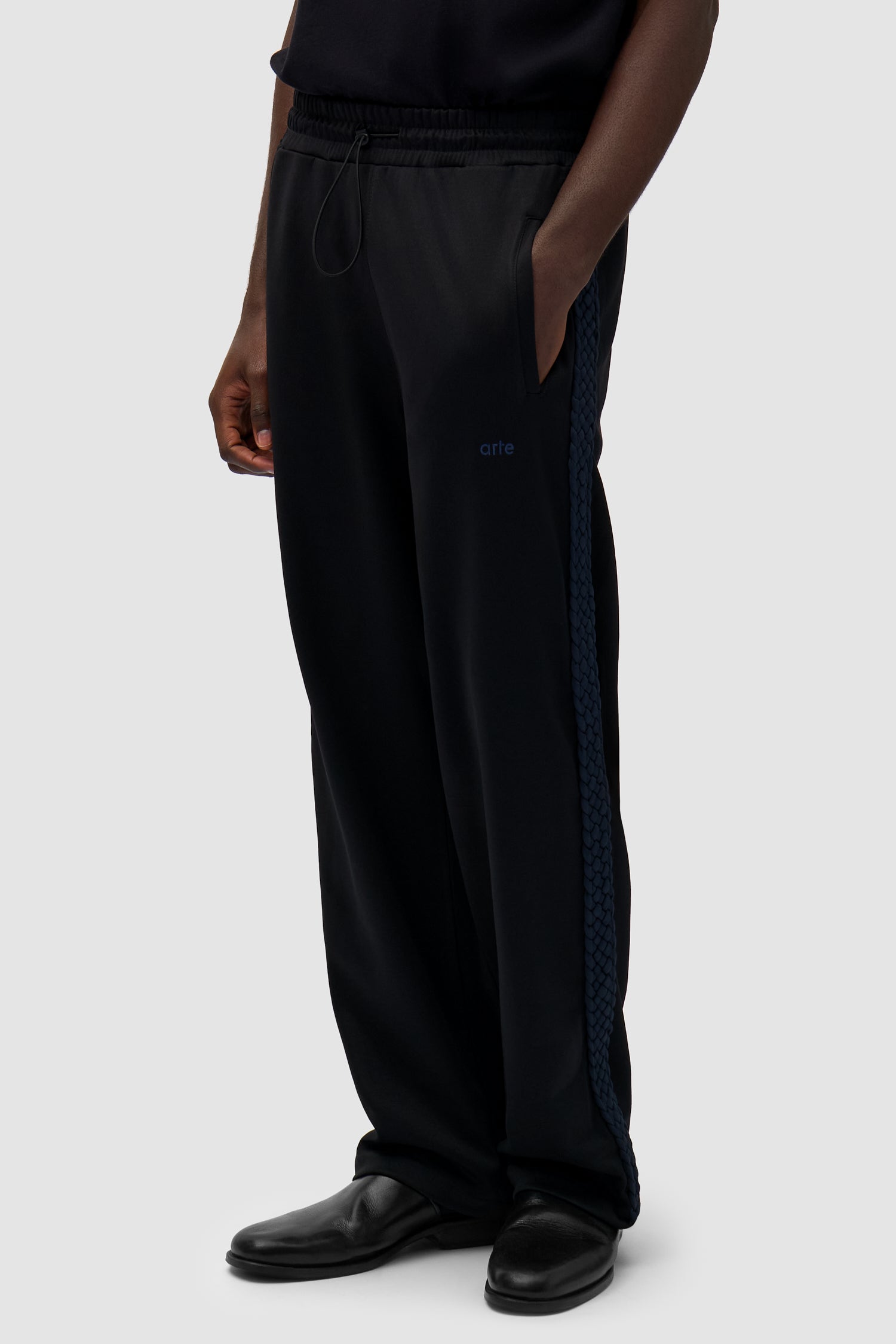Braid Strip Pants in Black worn by a model, half-body side view