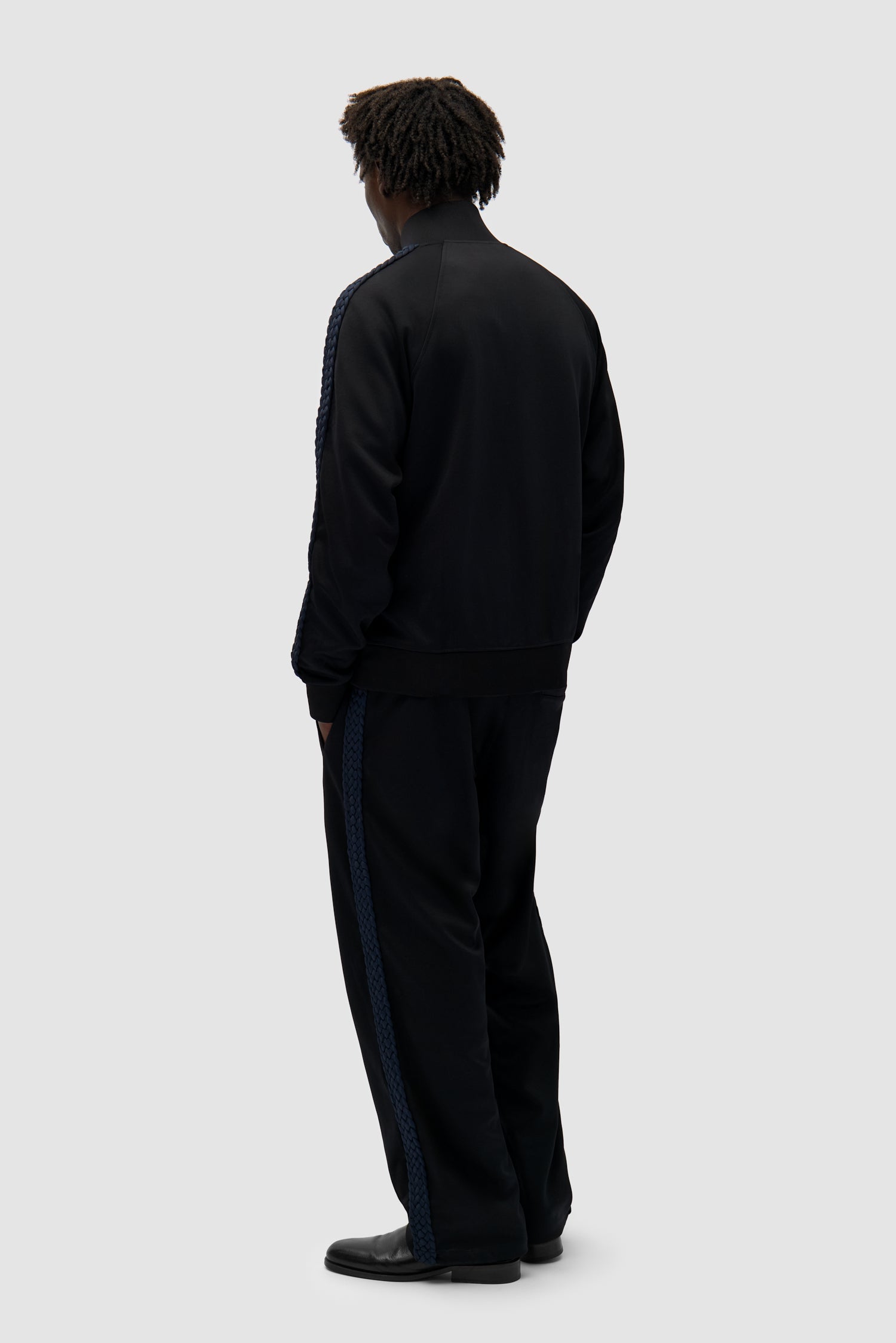 Braid Strip Pants in Black worn by a model, full-body back view