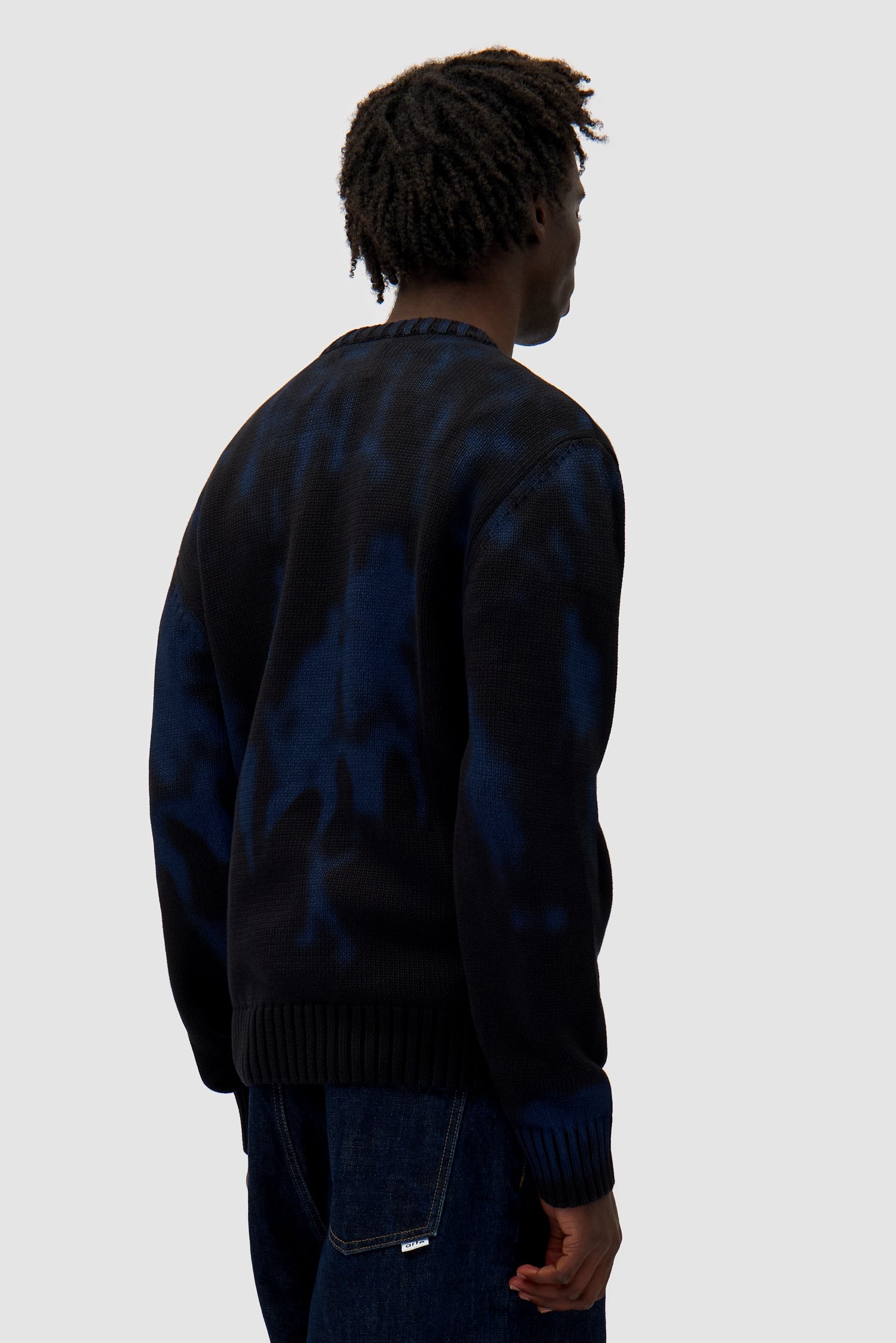 People Knit Sweater in Black/Navy worn by a model, half-body back view