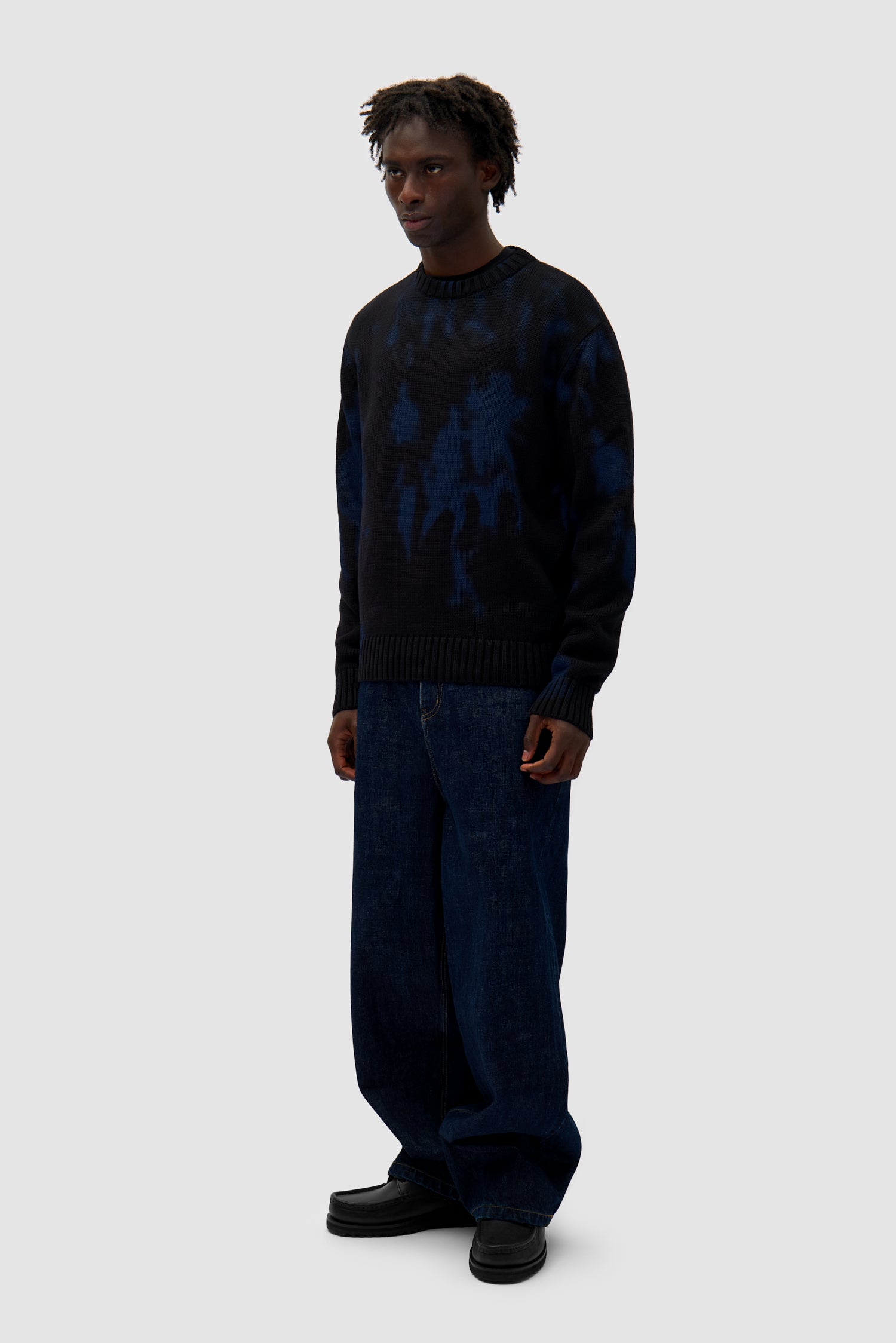 People Knit Sweater in Black/Navy worn by a model, full-body side view