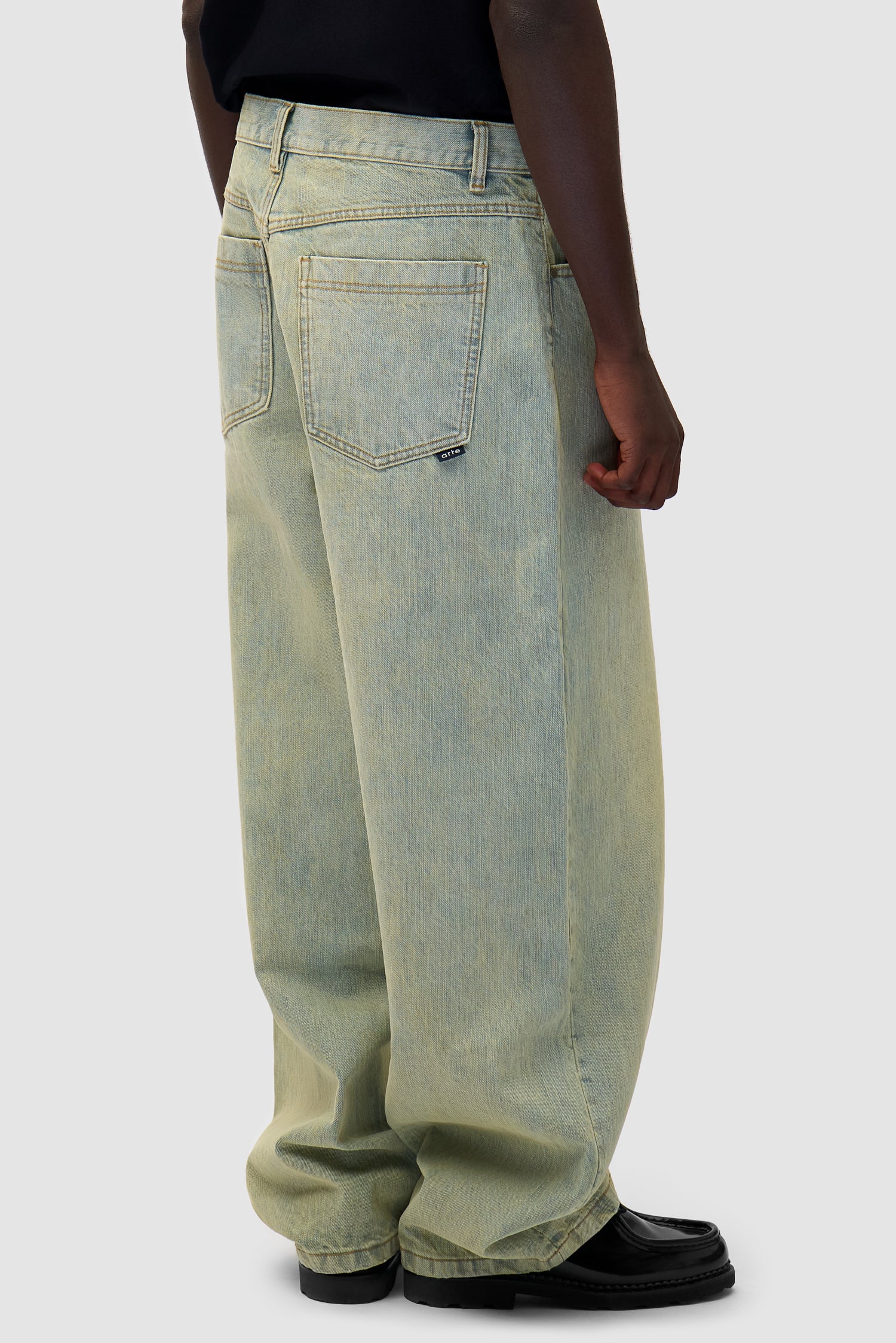 Denim Pants in Dirty Wash worn by a model, half-body back view