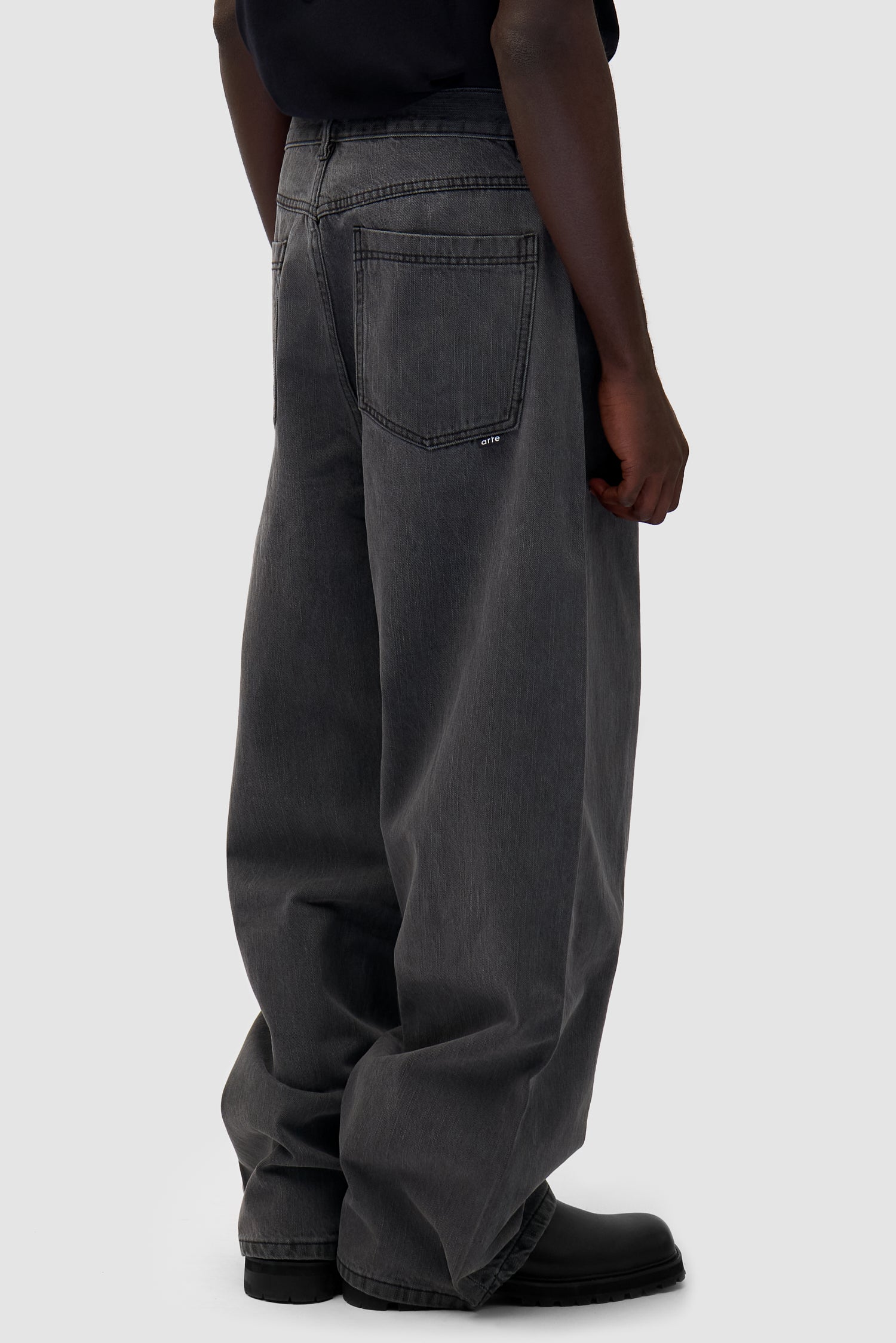 Denim Pants in Fade Black worn by a model, half-body back view