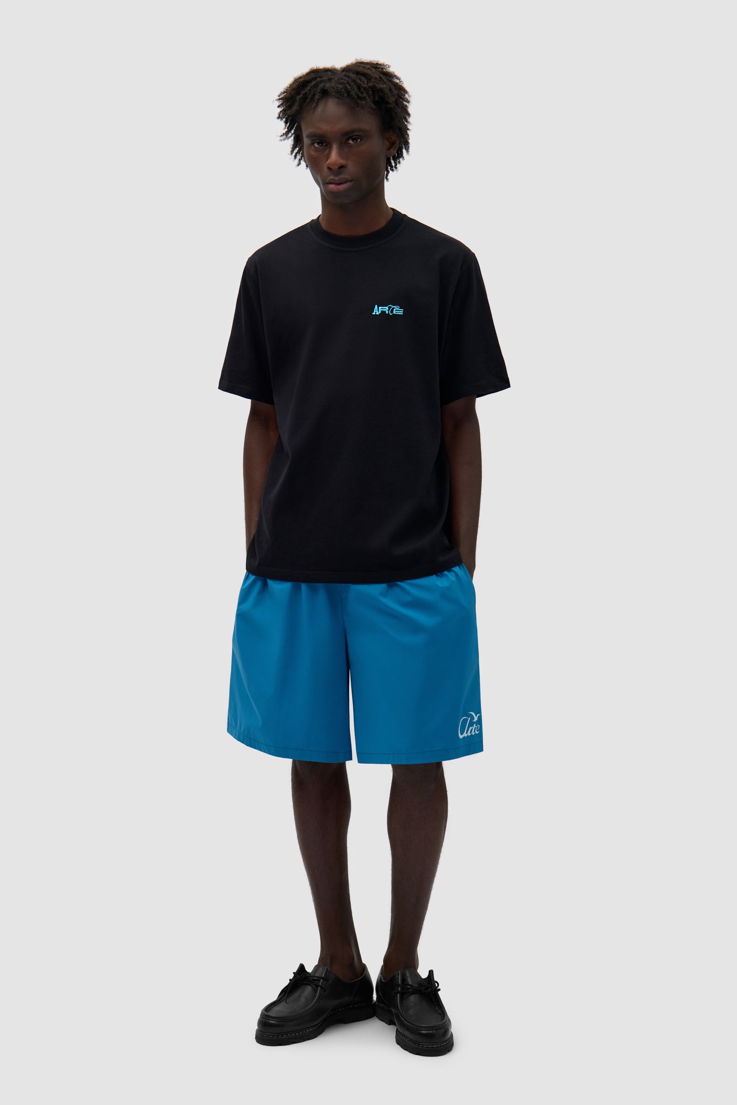 Back Logo People T-shirt in Black worn by a model, full-body side view