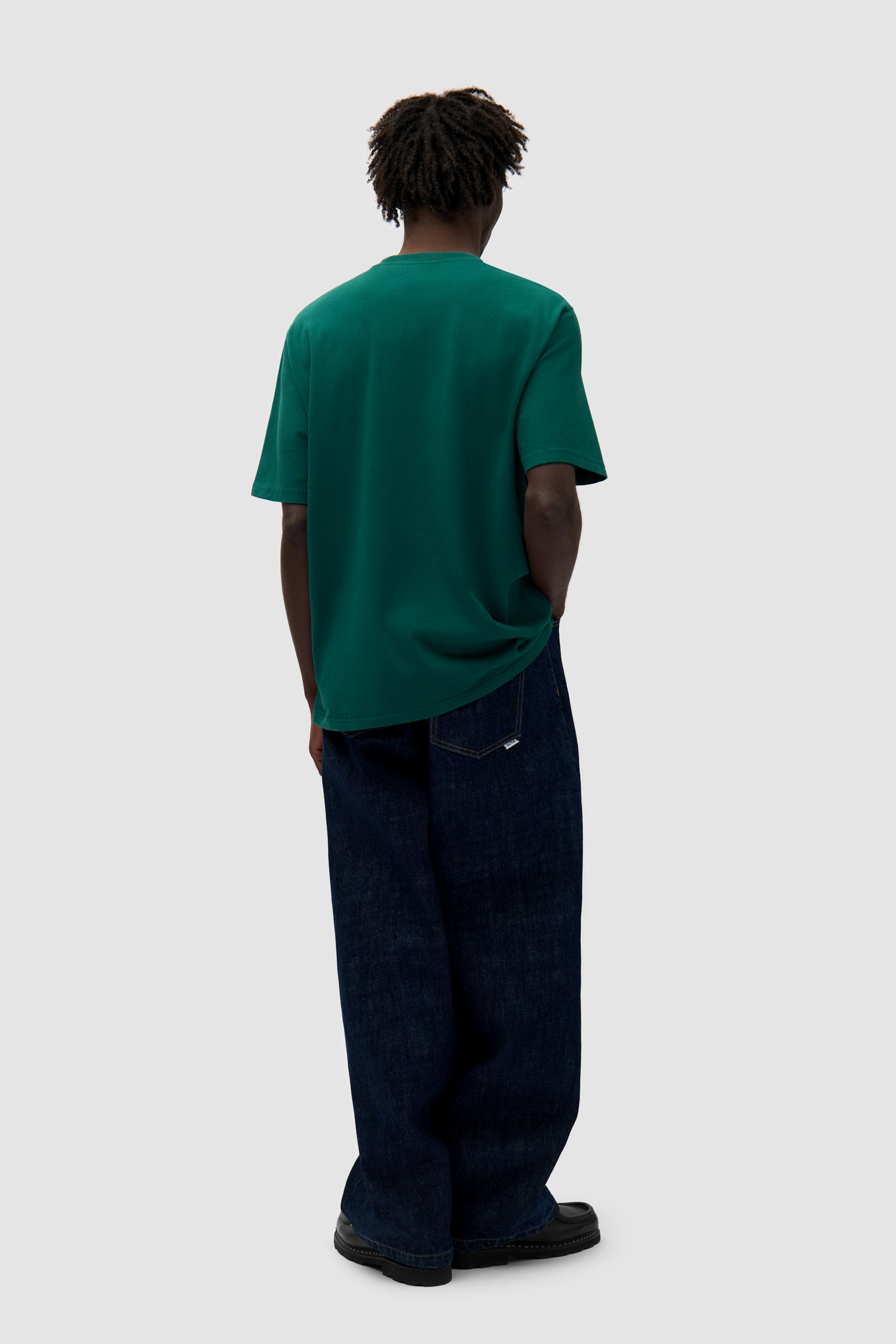 Small Bird T-shirt in Green worn by a model, full-body side view
