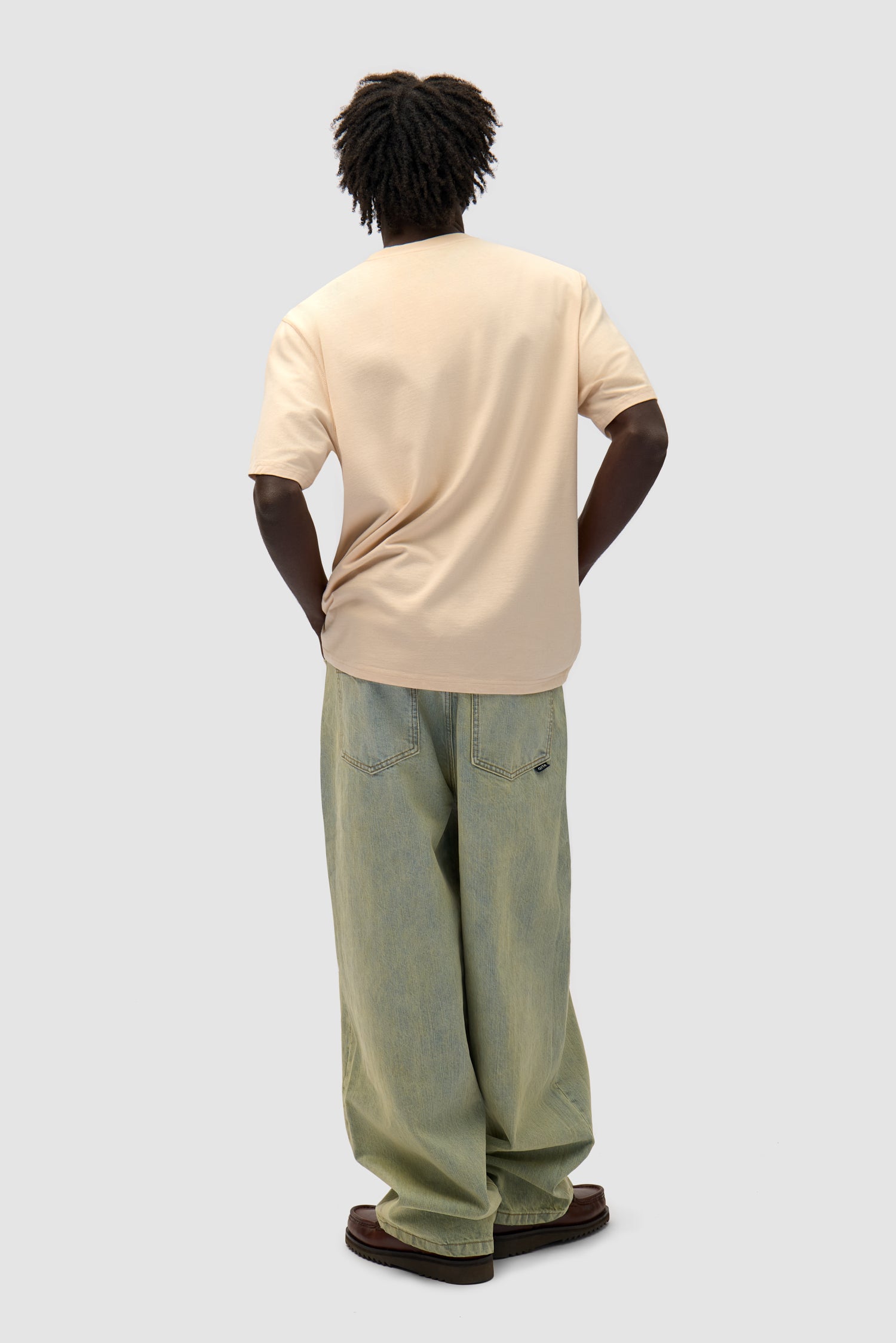 Multi Logo T-shirt in Cream worn by a model, full-body back view