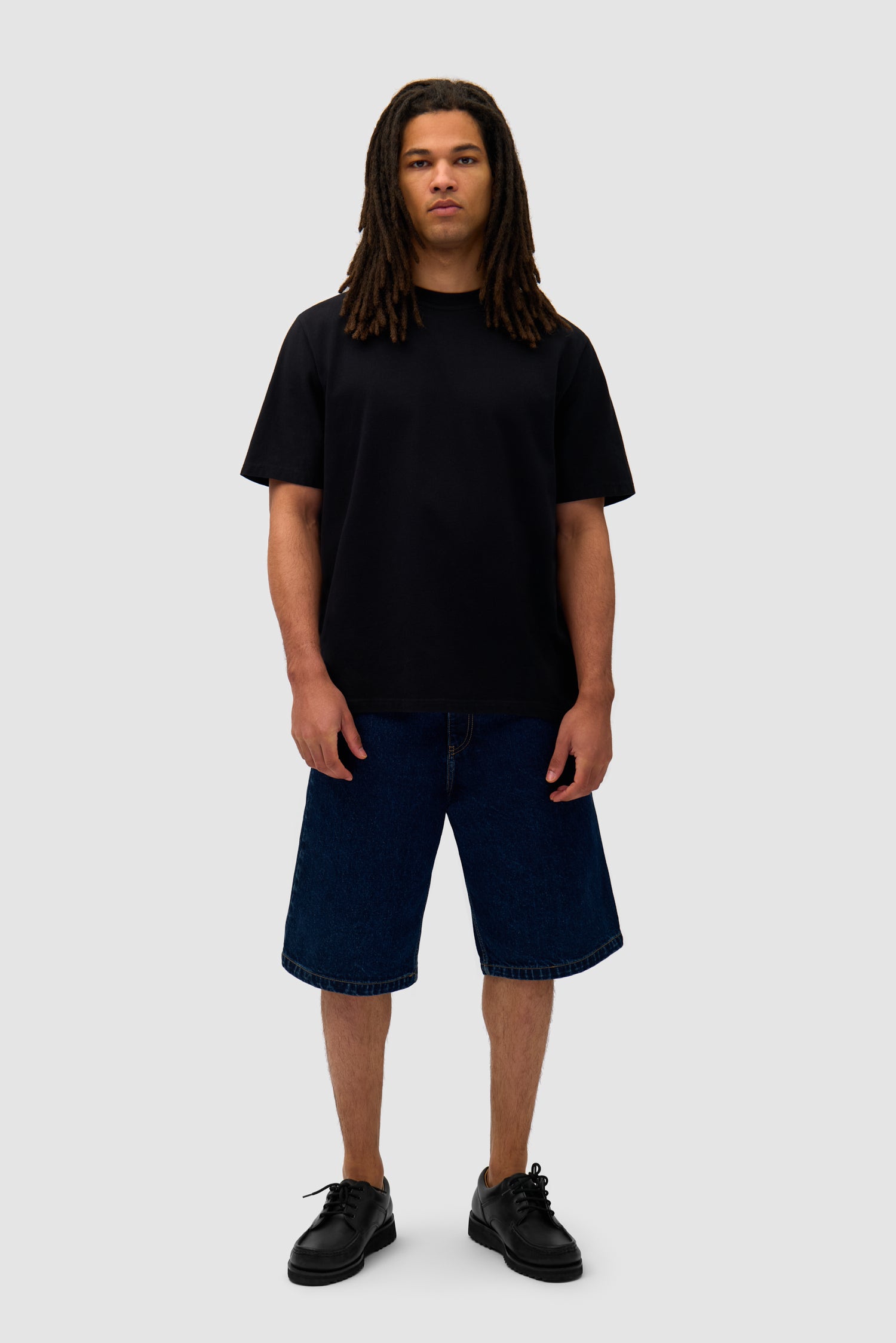 Energy T-shirt in Black worn by a model, full-body side view