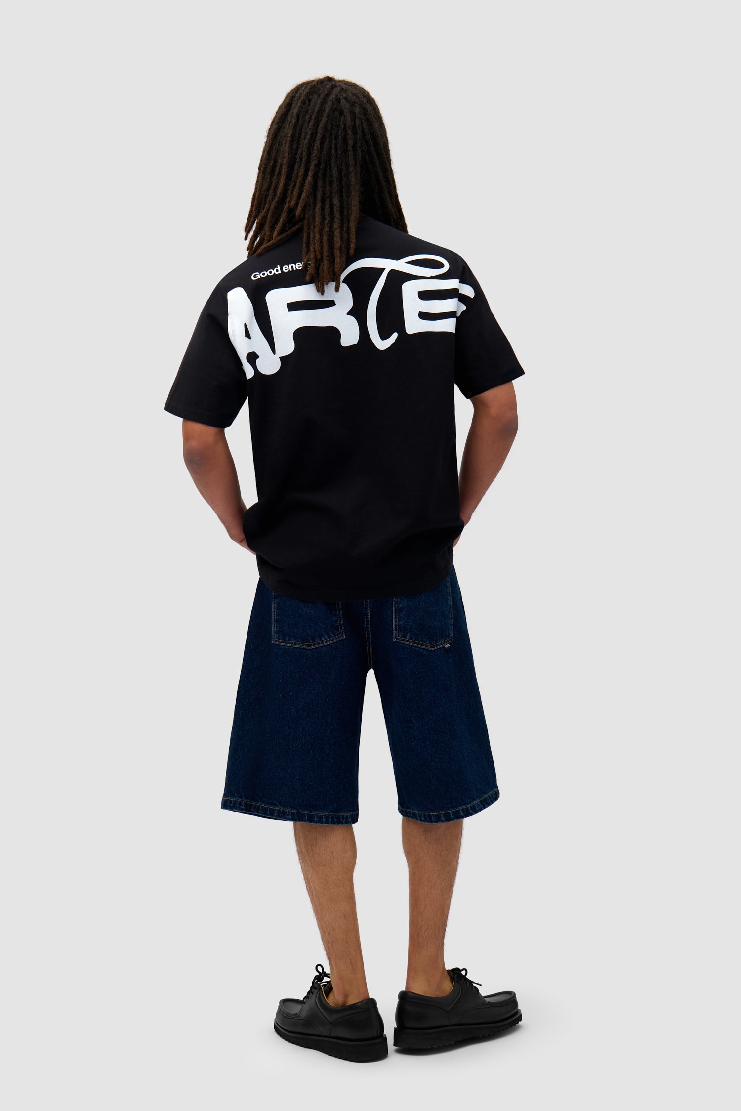 Energy T-shirt in Black worn by a model, full-body front view