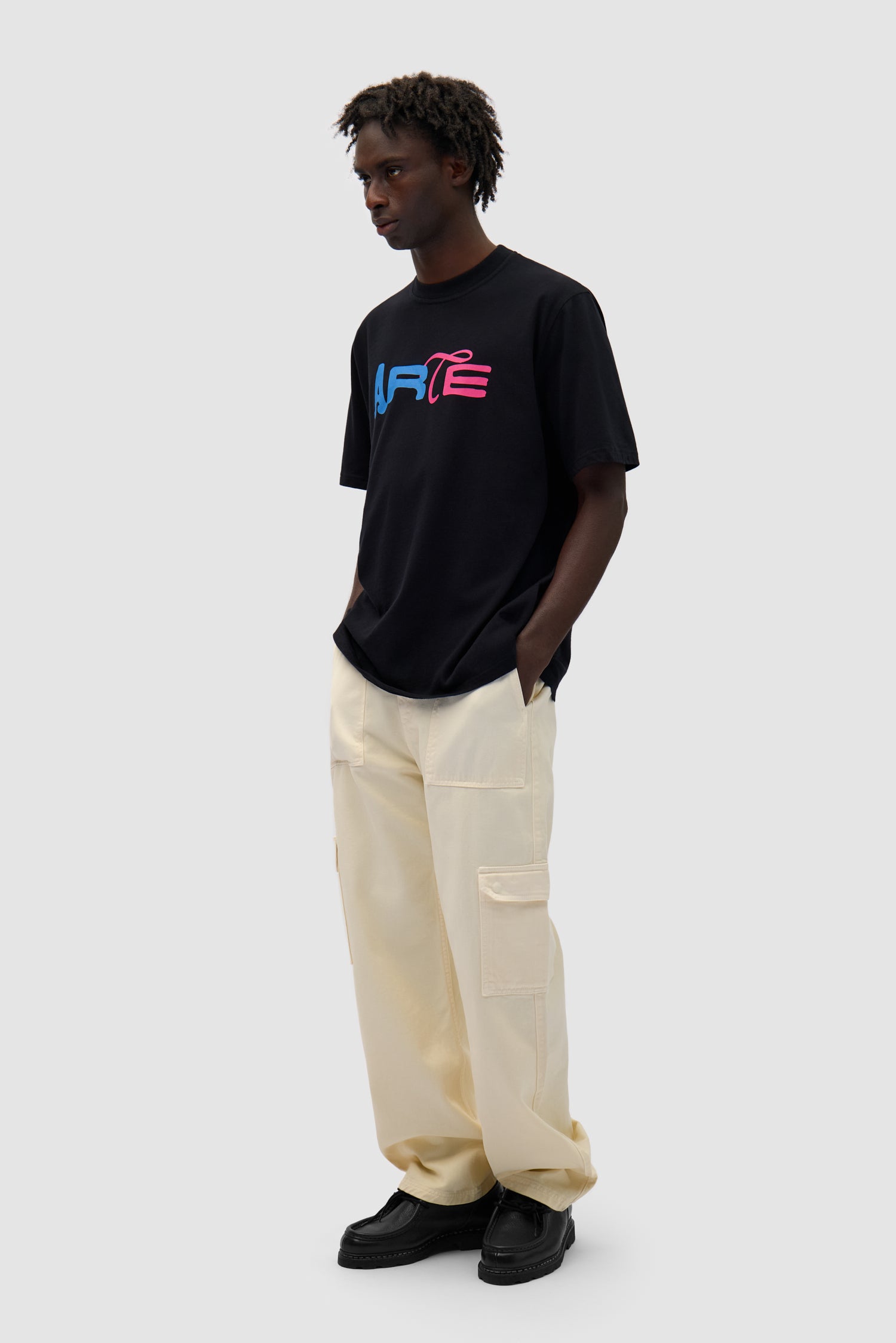 Duo Print Logo T-shirt in Black worn by a model, full-body side view