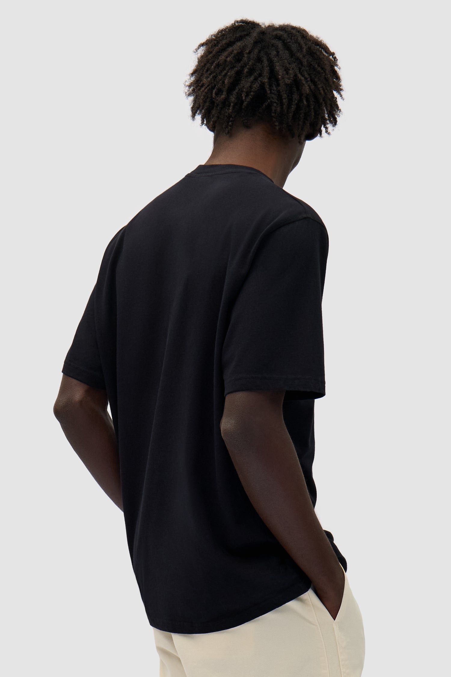 Duo Print Logo T-shirt in Black worn by a model, half-body back view
