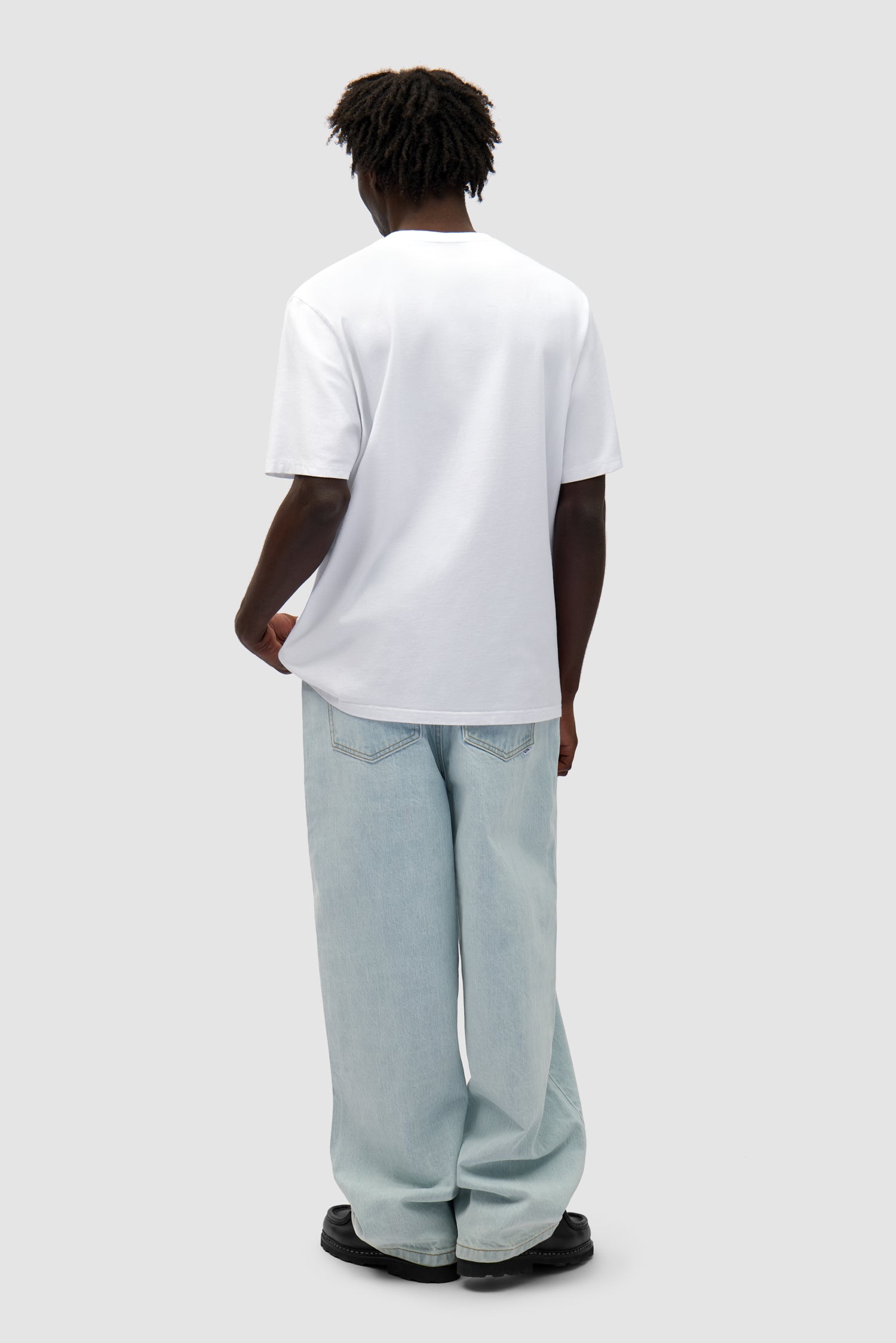 Duo Print Logo T-shirt in White worn by a model, full-body back view