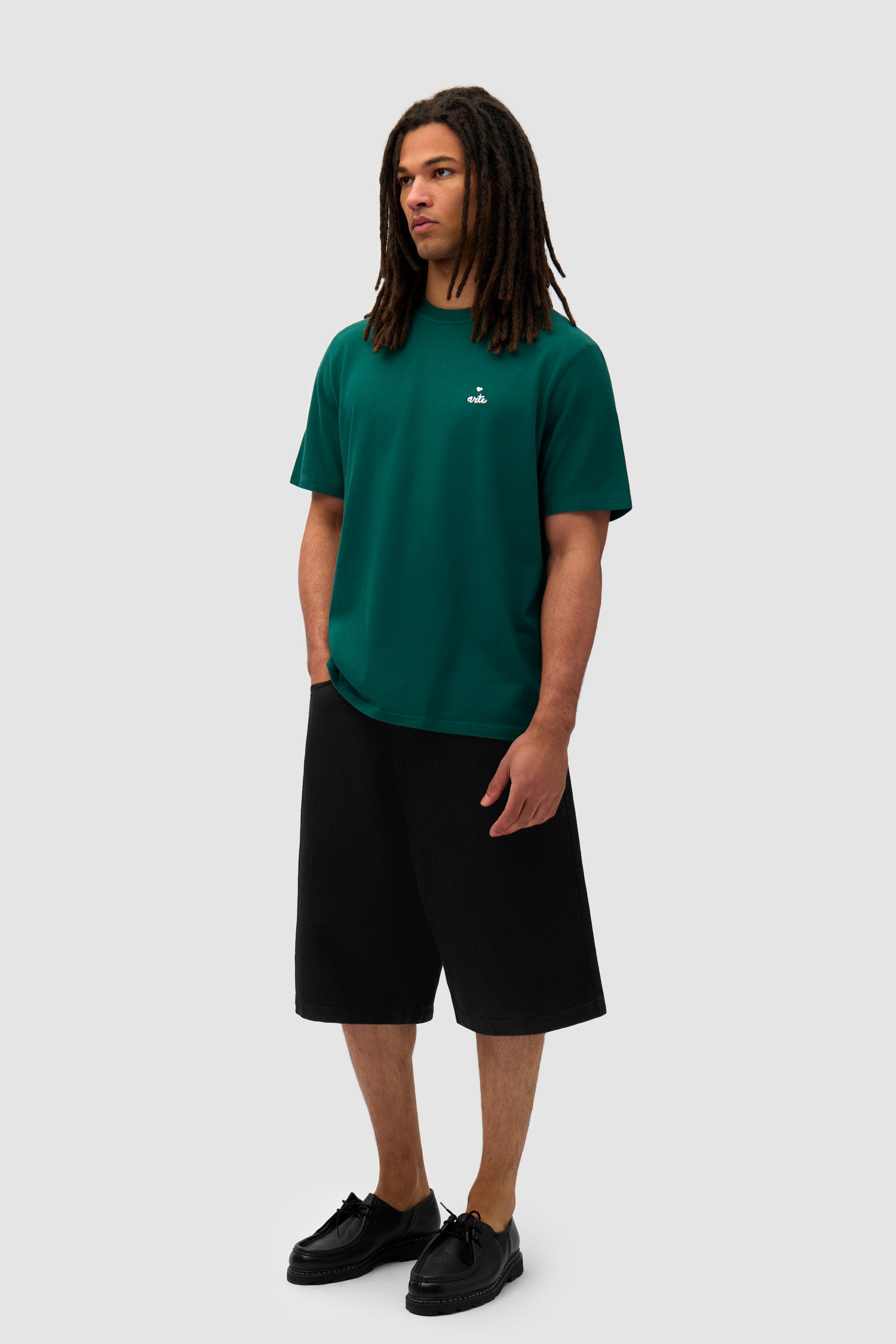 Heart Logo T-shirt in Green worn by a model, full-body side view