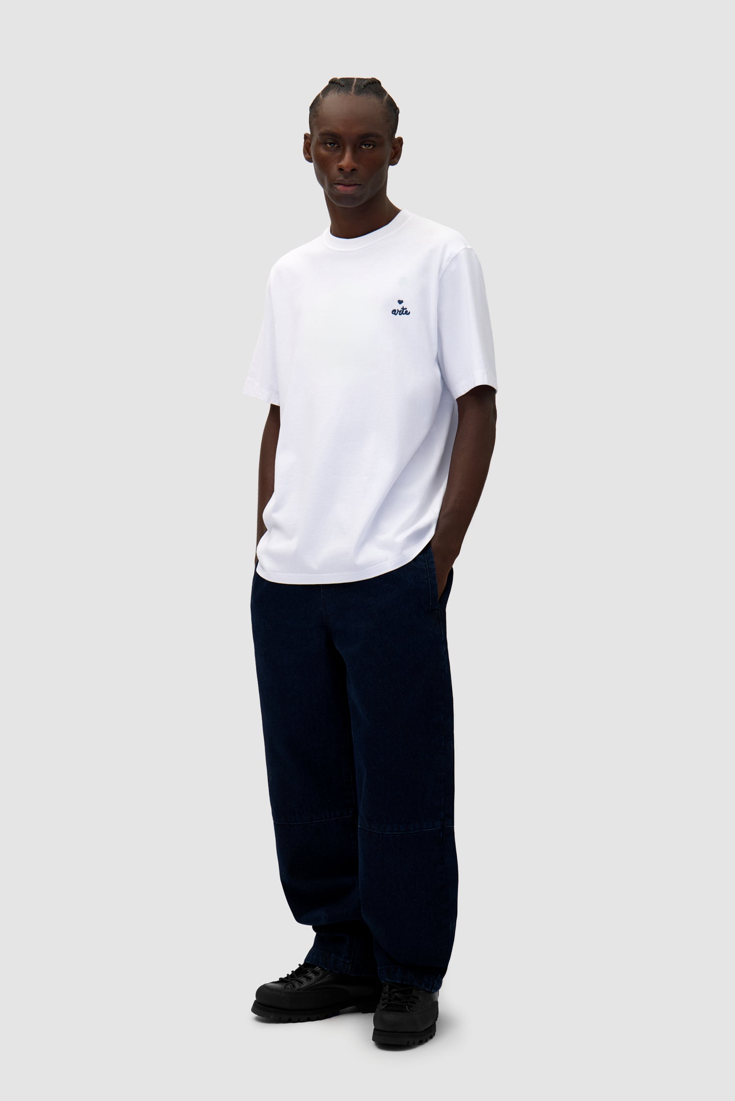 Heart Logo T-shirt in White worn by a model, full-body side view