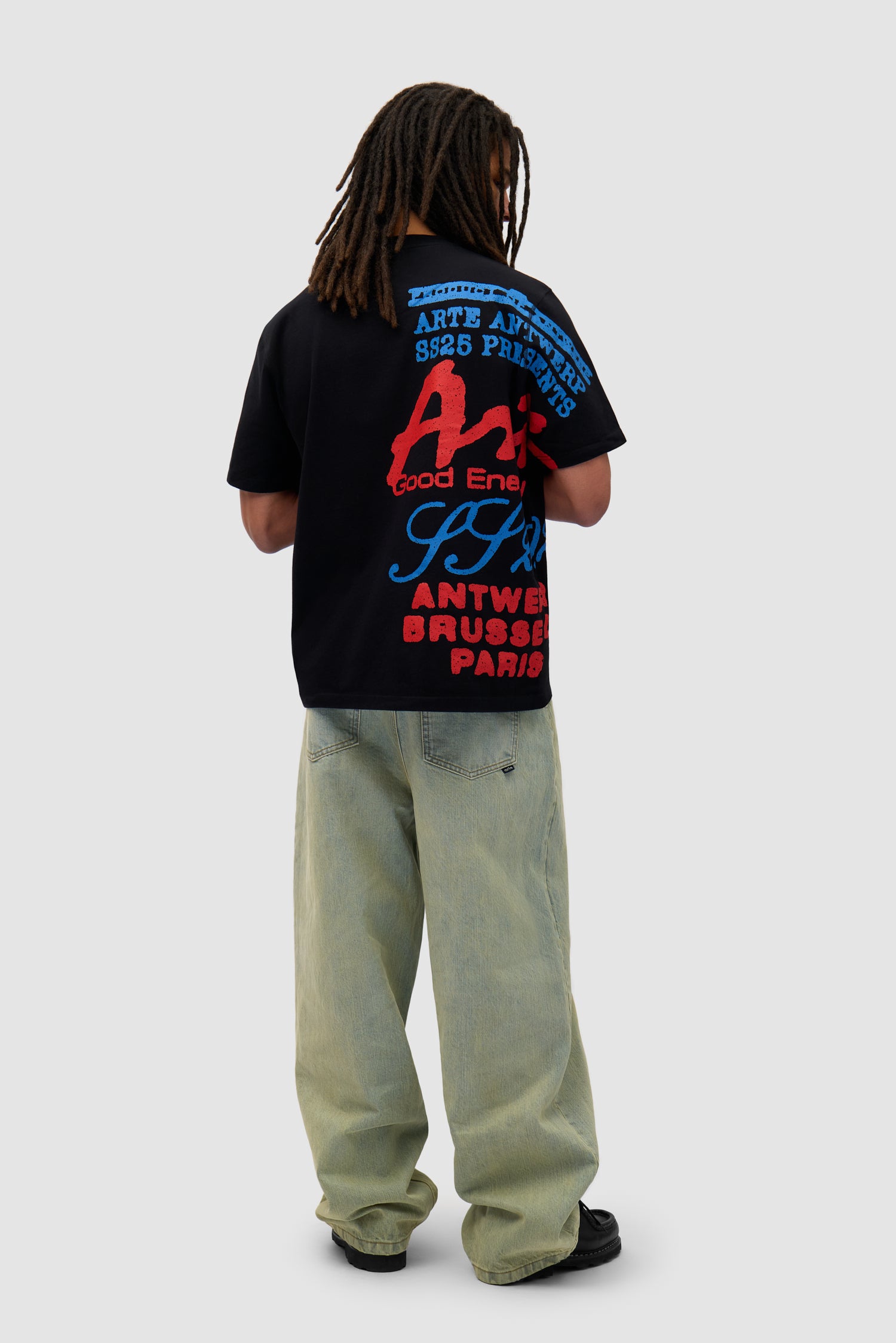 Side Print T-shirt in Black worn by a model, full-body side view