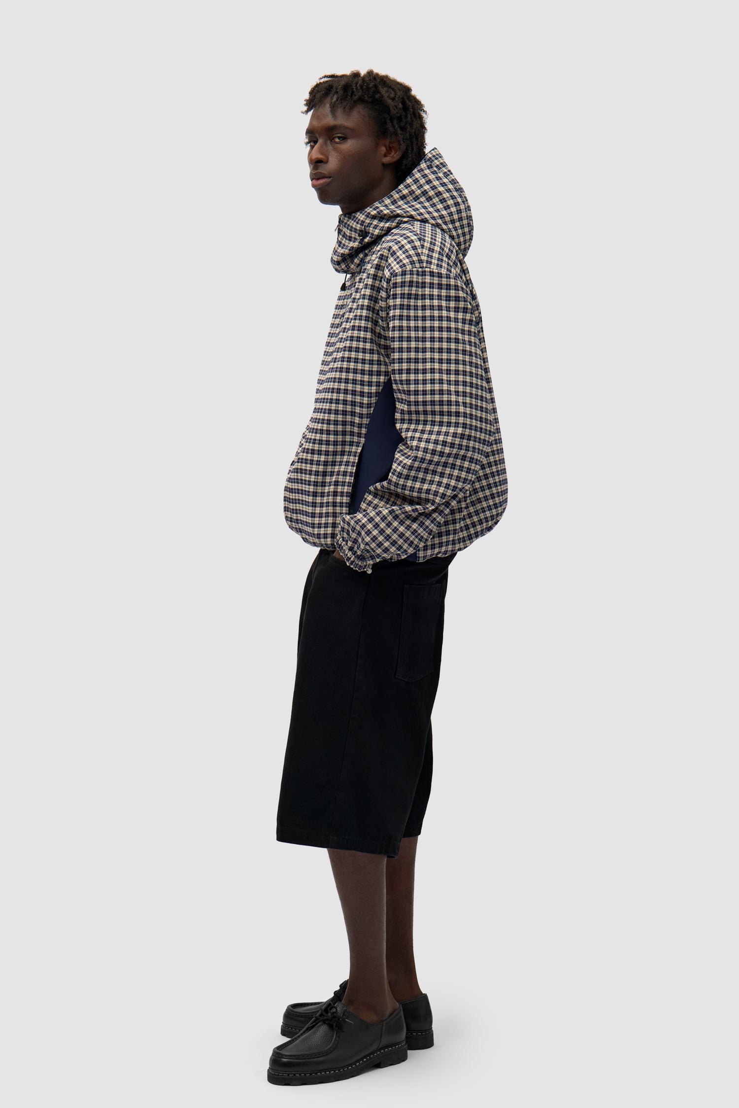 Reversible Plaid Technical Jacket in Navy/Plaid worn by a model, full-body side view, plaid side
