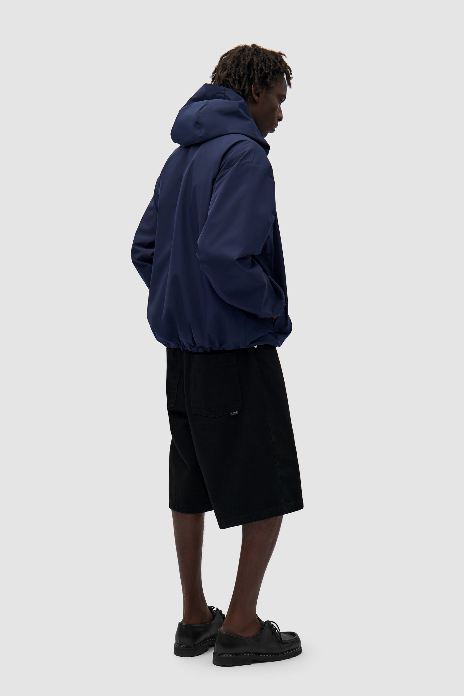 Reversible Plaid Technical Jacket in Navy/Plaid worn by a model, full-body side view, navy side