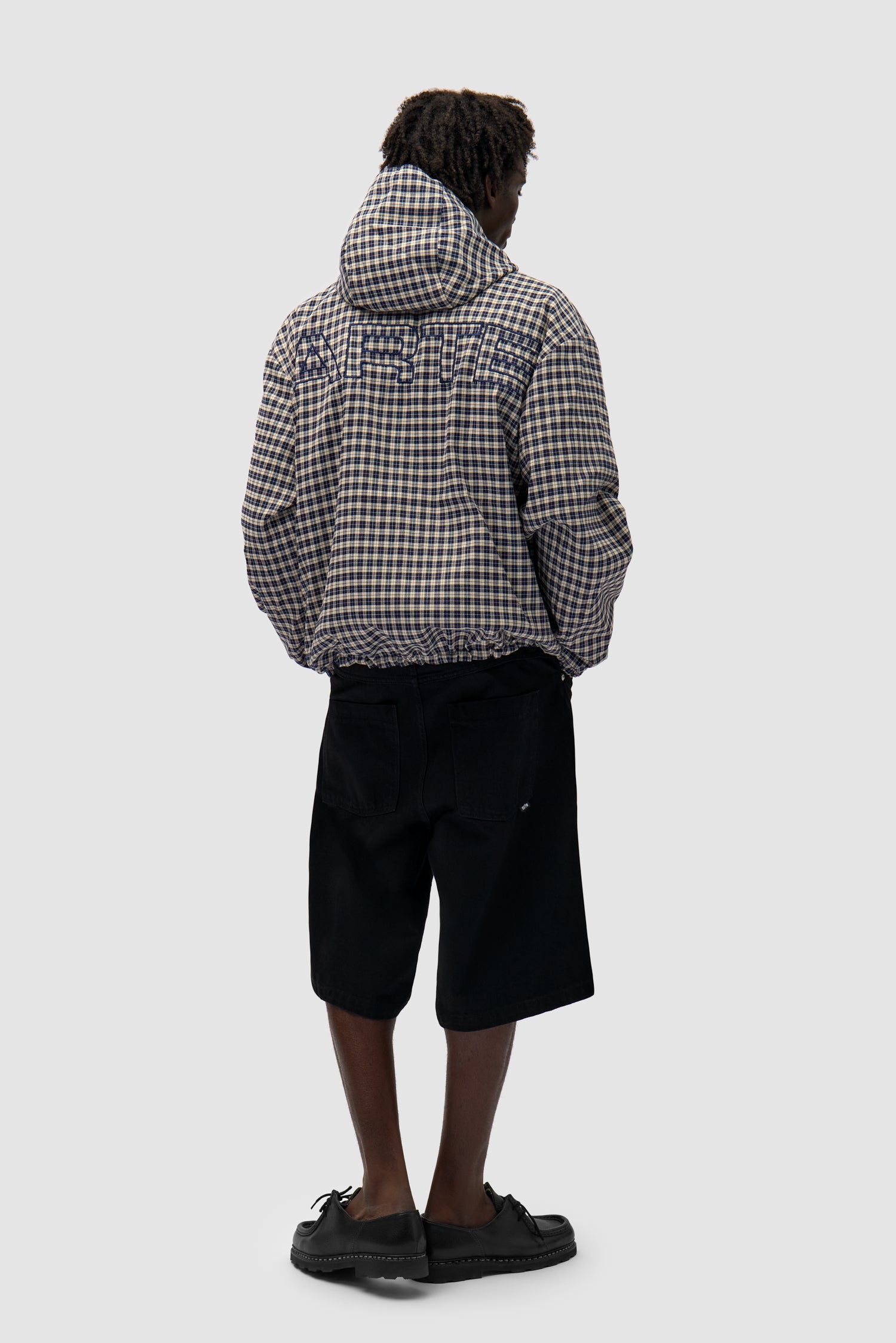 Reversible Plaid Technical Jacket in Navy/Plaid worn by a model, full-body back view, navy side