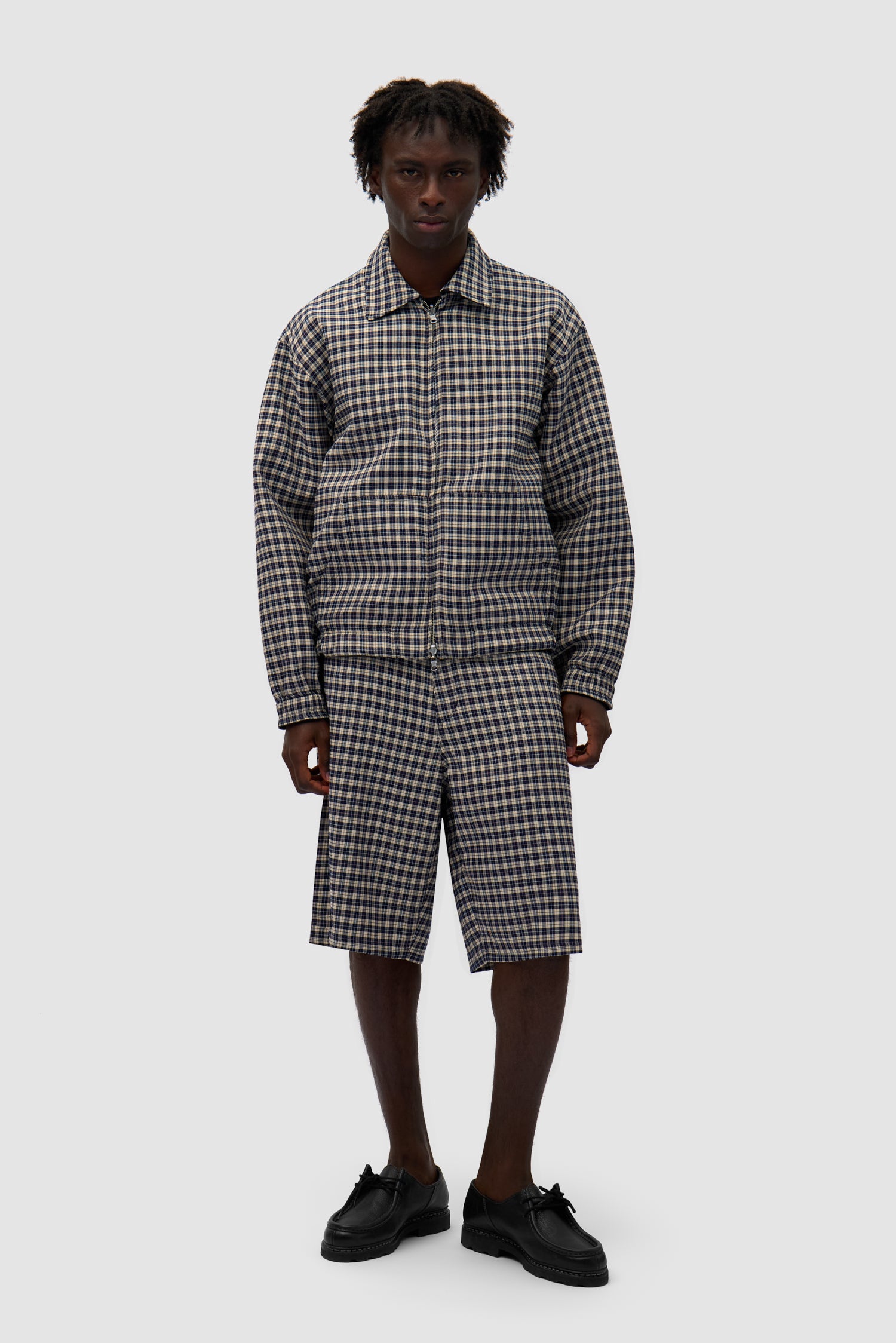 Reversible Plaid Leather Jacket in Black/Plaid worn reversed by a model, full-body front view