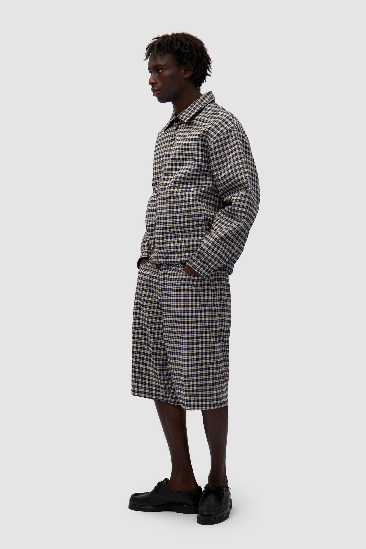 Reversible Plaid Leather Jacket in Black/Plaid worn reversed by a model, full-body side view