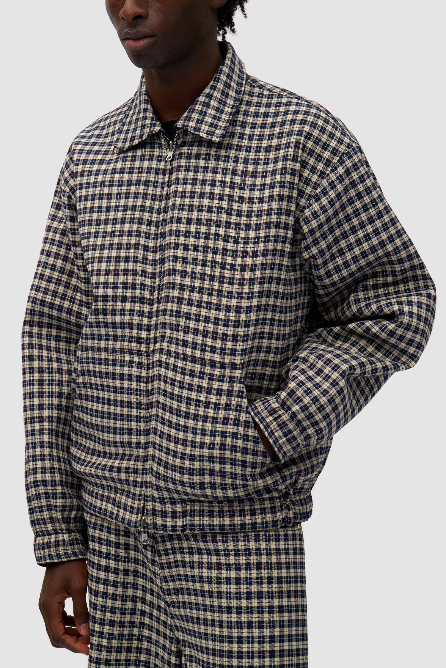 Reversible Plaid Leather Jacket in Black/Plaid worn reversed by a model, half-body front view, pocket detail