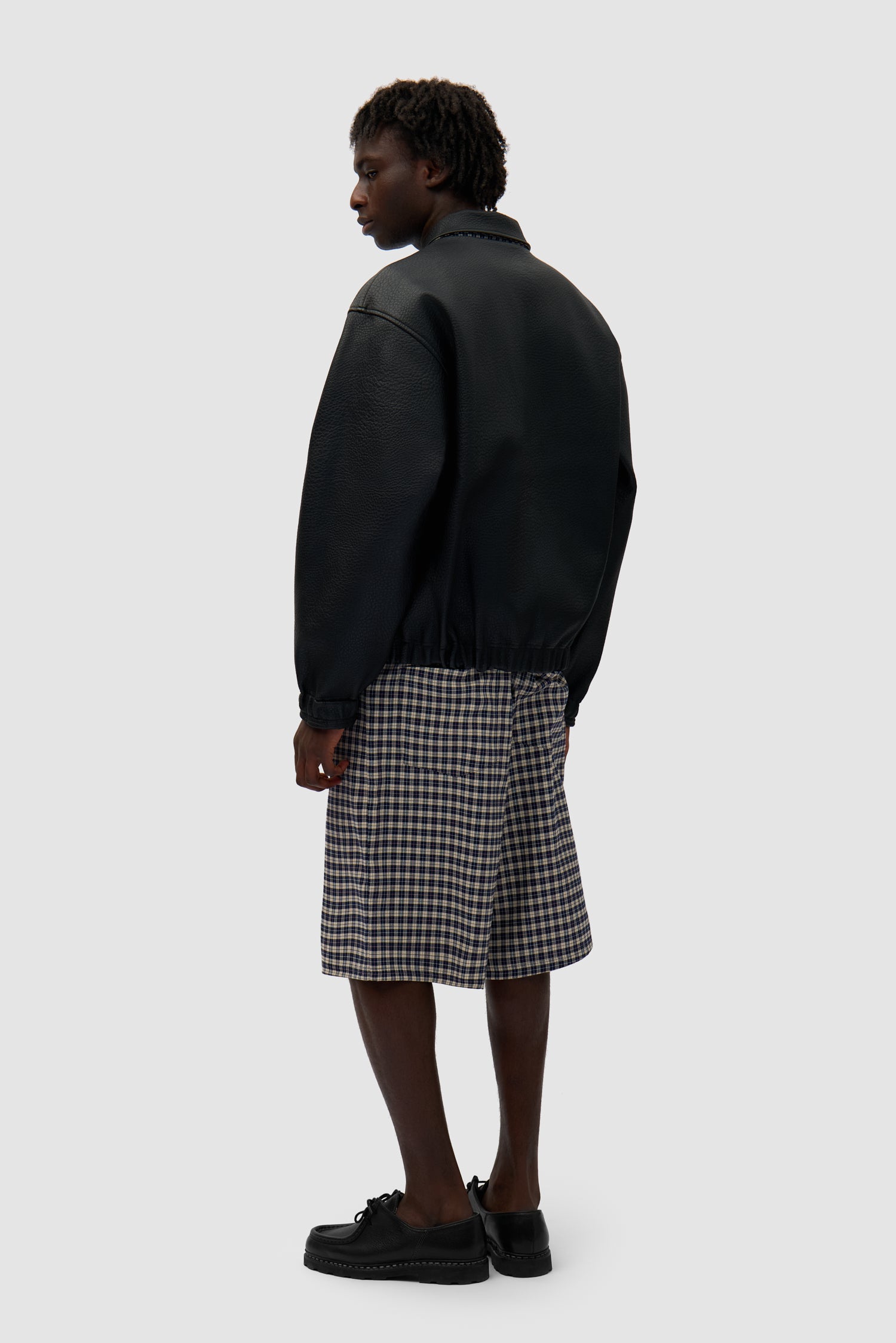 Reversible Plaid Leather Jacket in Black/Plaid worn by a model, full-body back view