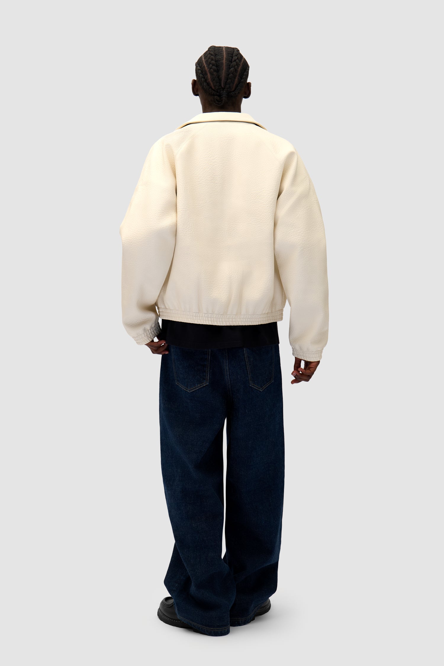 Big Logo Leather Jacket in Cream worn by a model, full-body side view