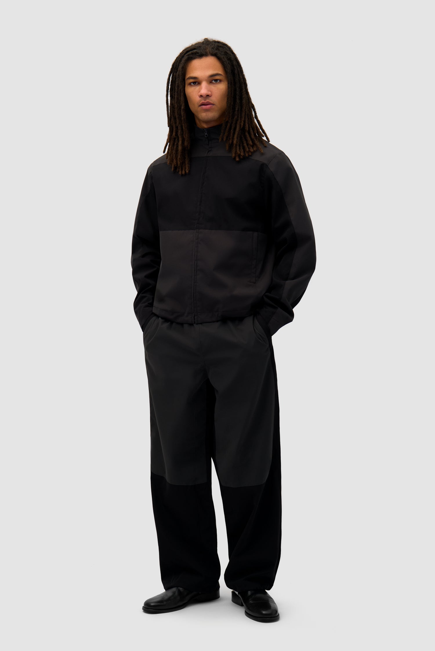 Tracksuit Jacket in Black worn by a model, full-body front view