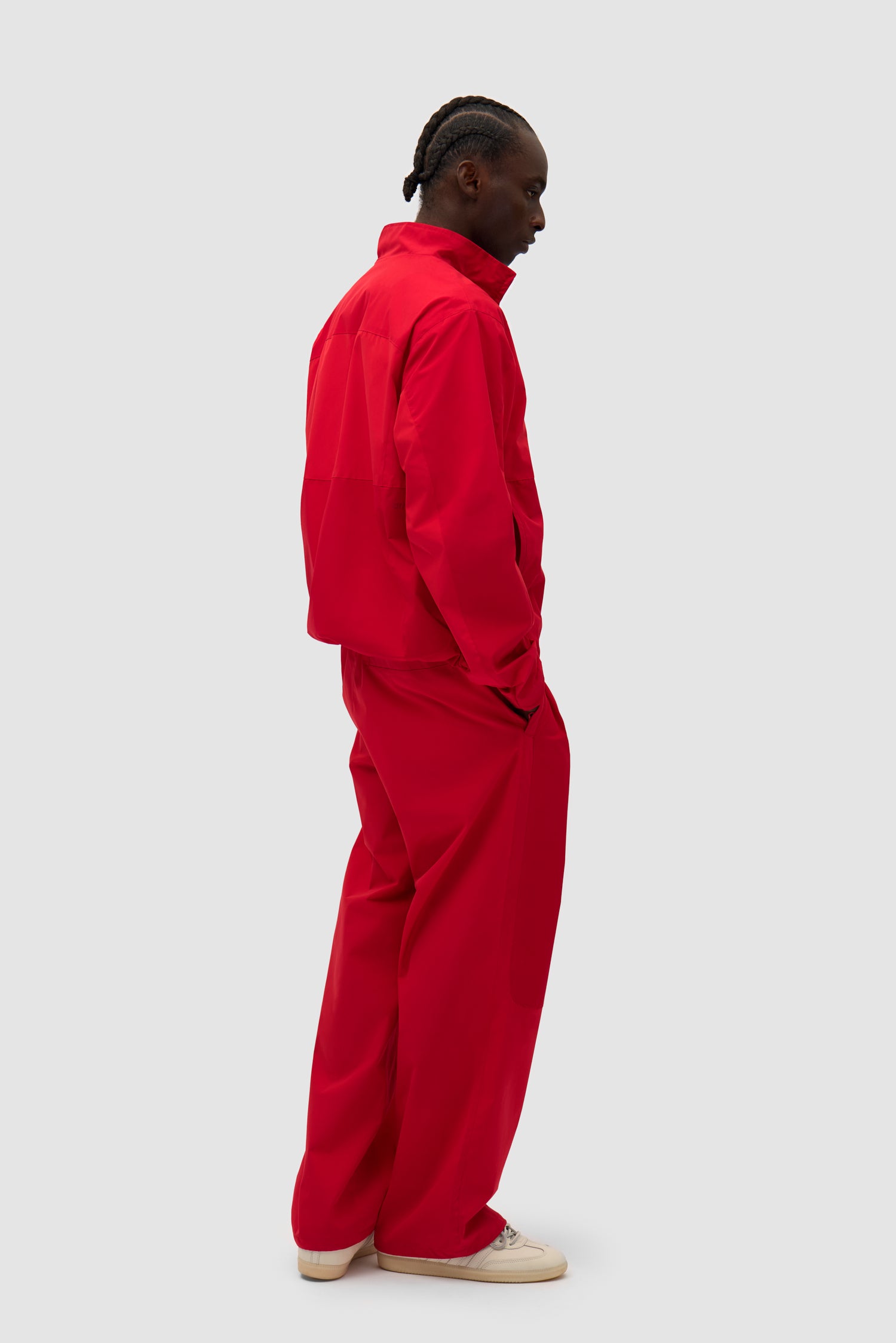 Tracksuit Jacket in Red worn by a model, full-body side view