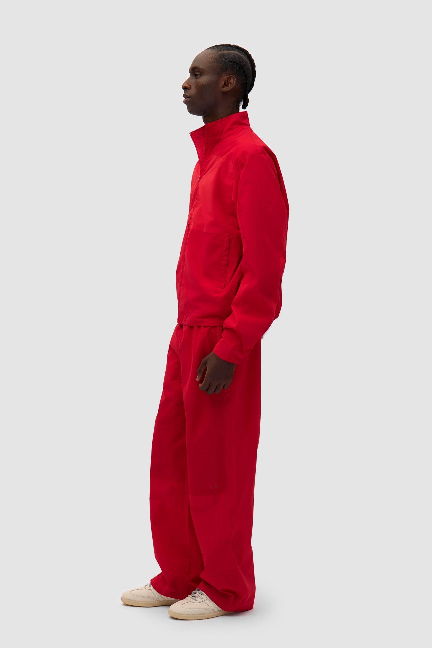 Tracksuit Pants in Red worn by a model, full-body side view