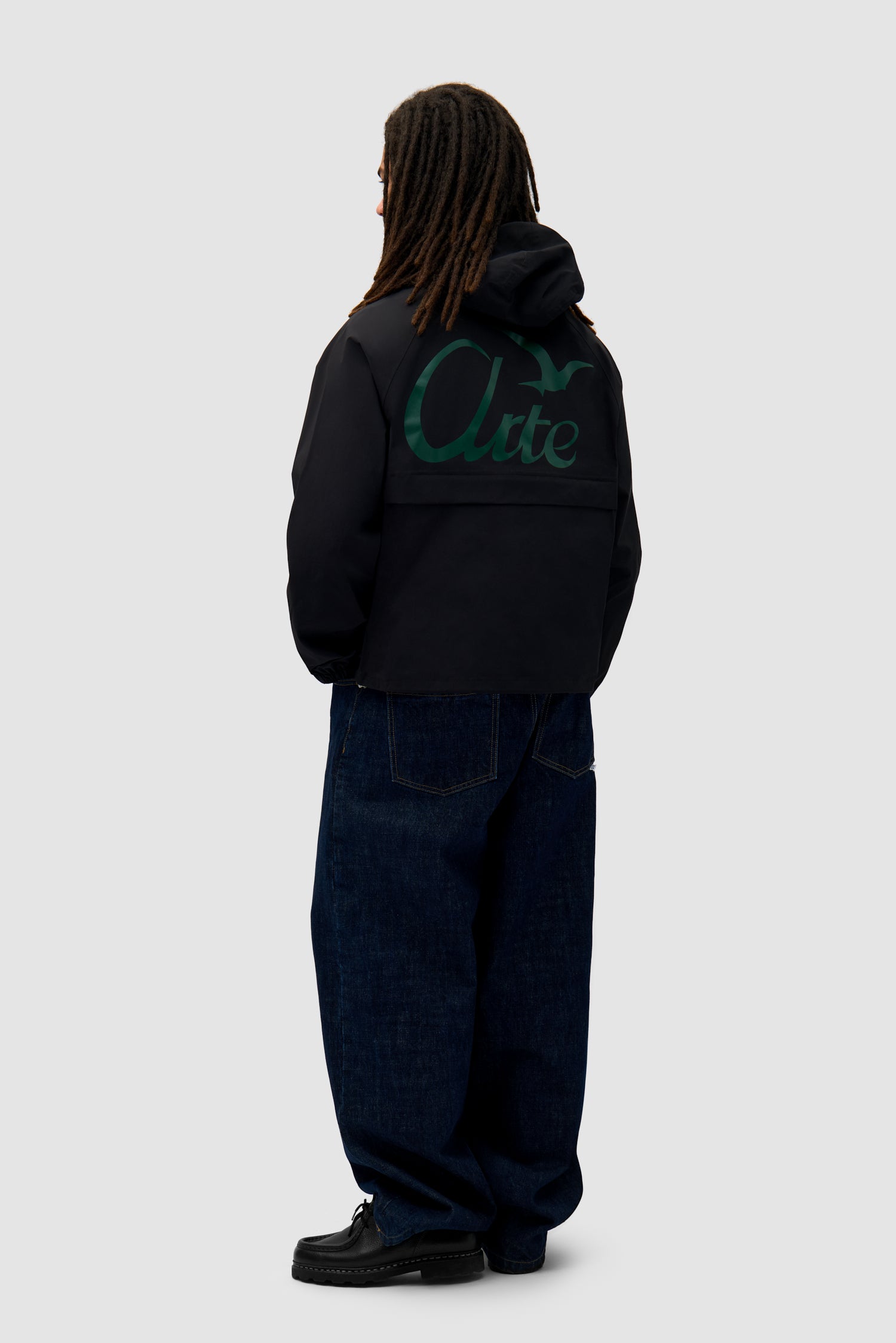 Bird Logo Anorak in Black worn by a model, full-body side view