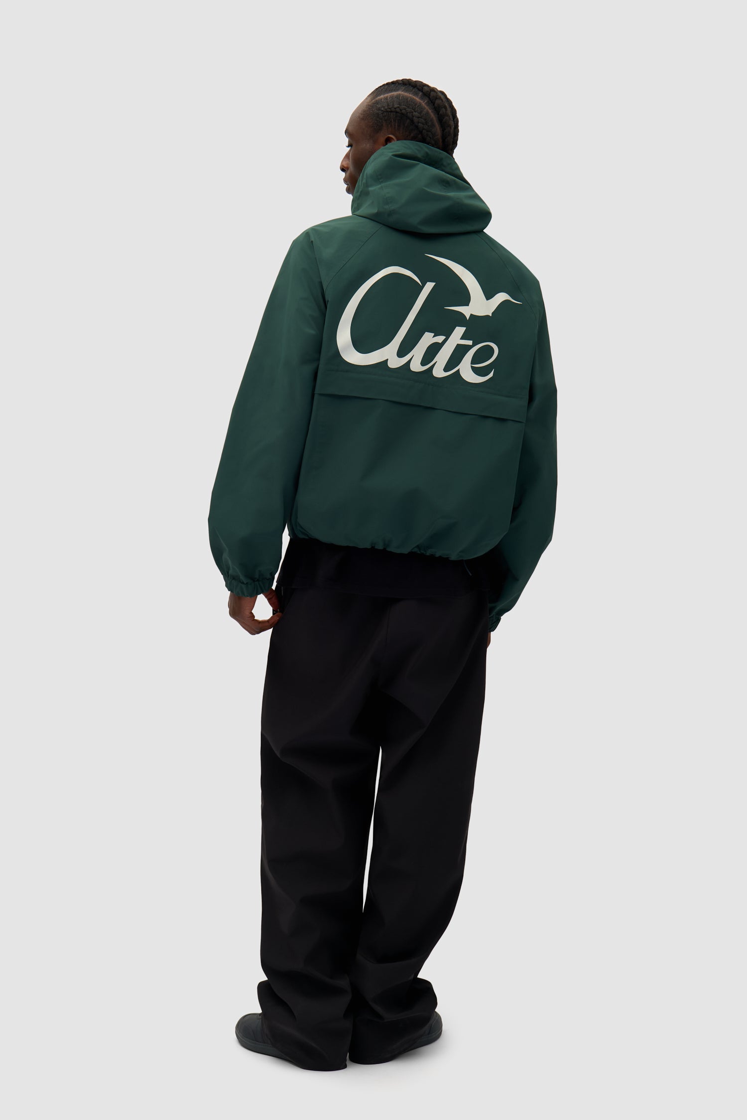 Bird Logo Anorak in Green worn by a model, full-body back view