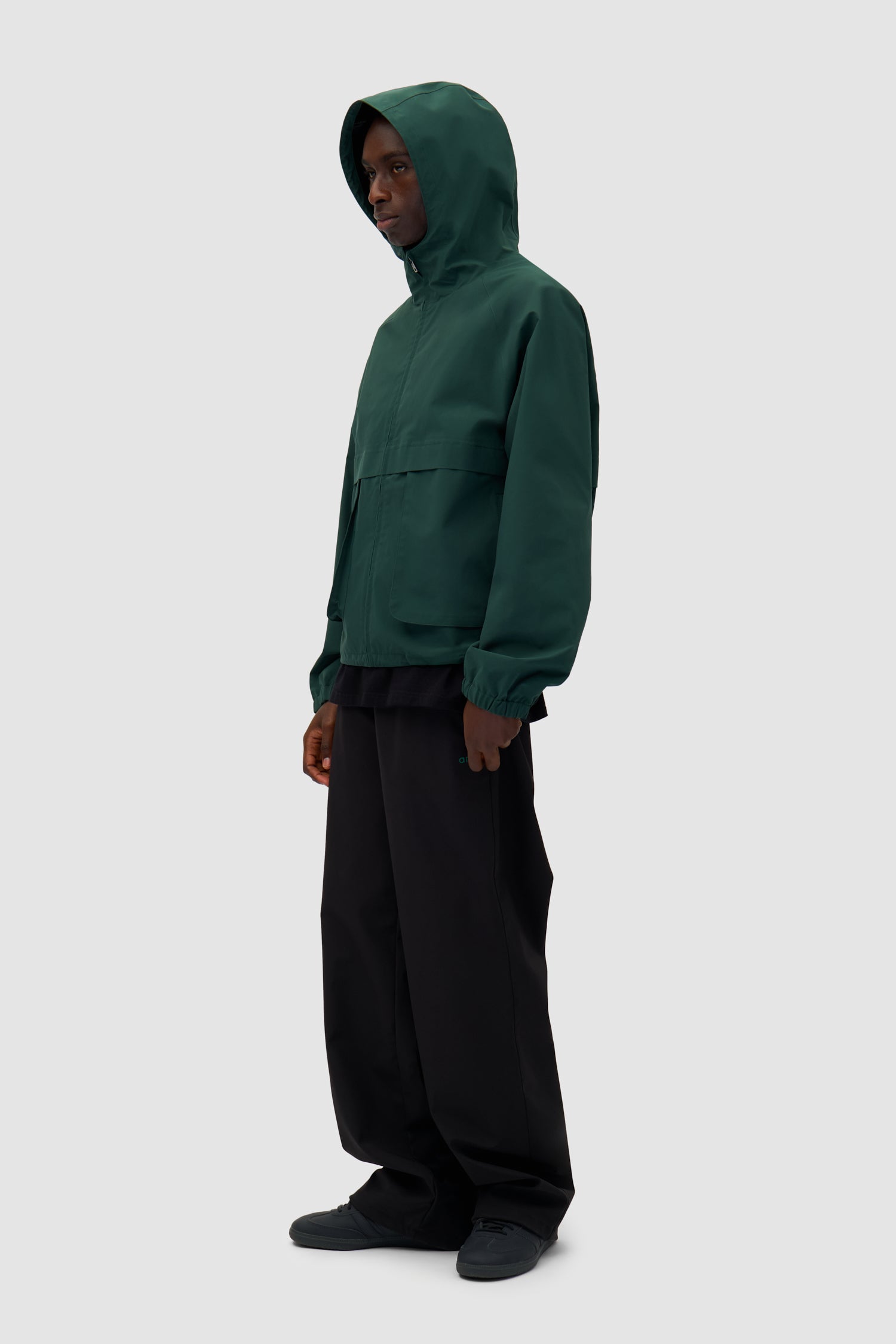 Bird Logo Anorak in Green worn by a model, full-body side view