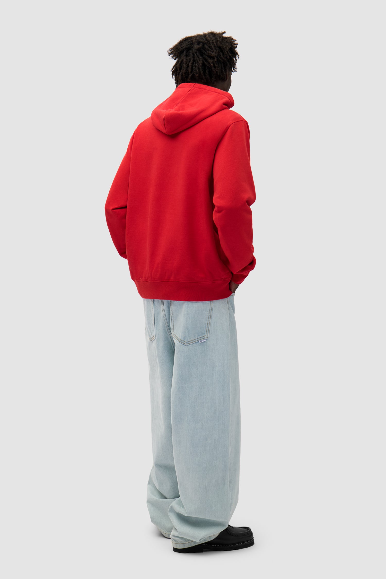 Big Bird Hoodie in Red worn by a model, full-body side view