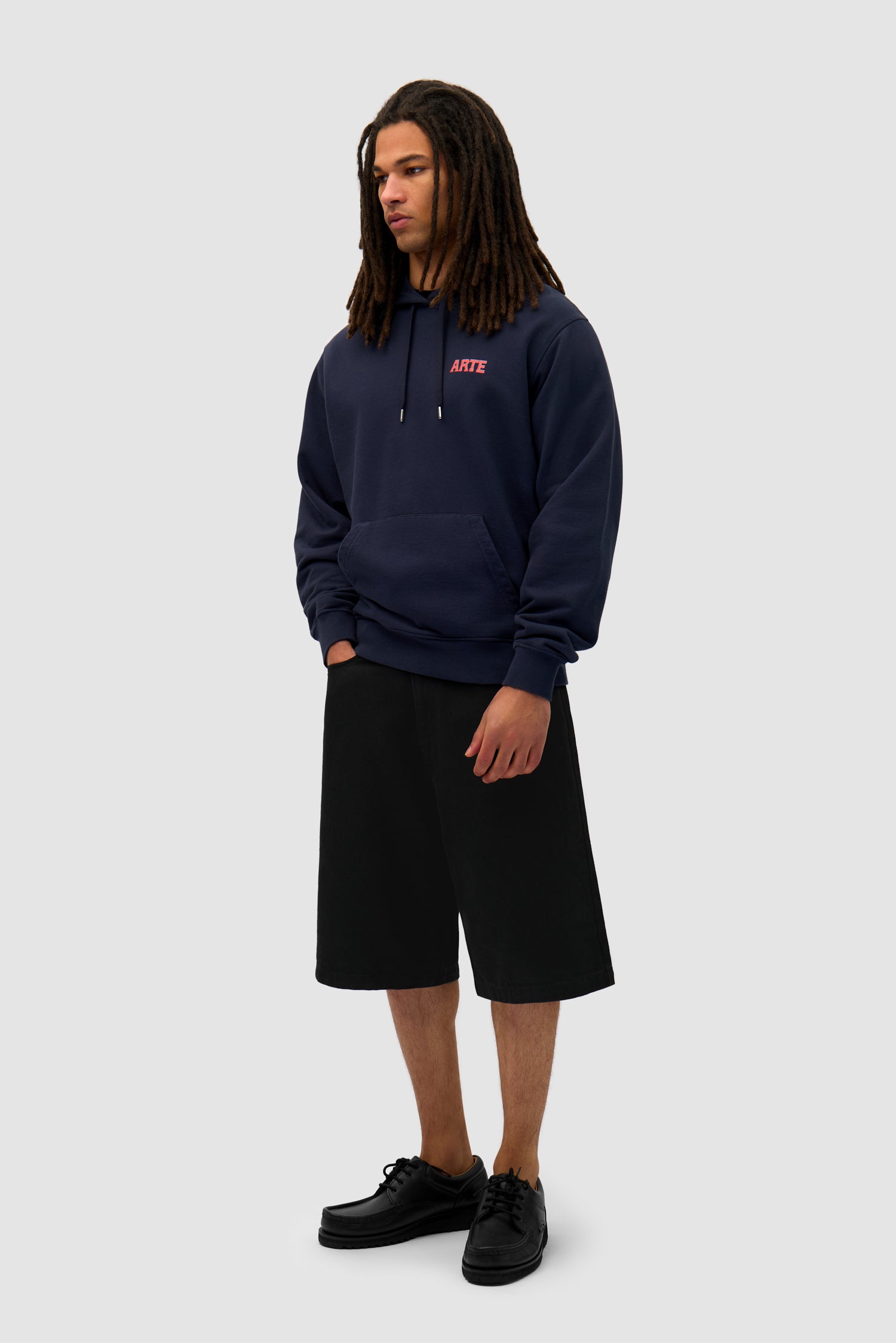 Mural Back Print Hoodie in Navy worn by a model, full-body side view