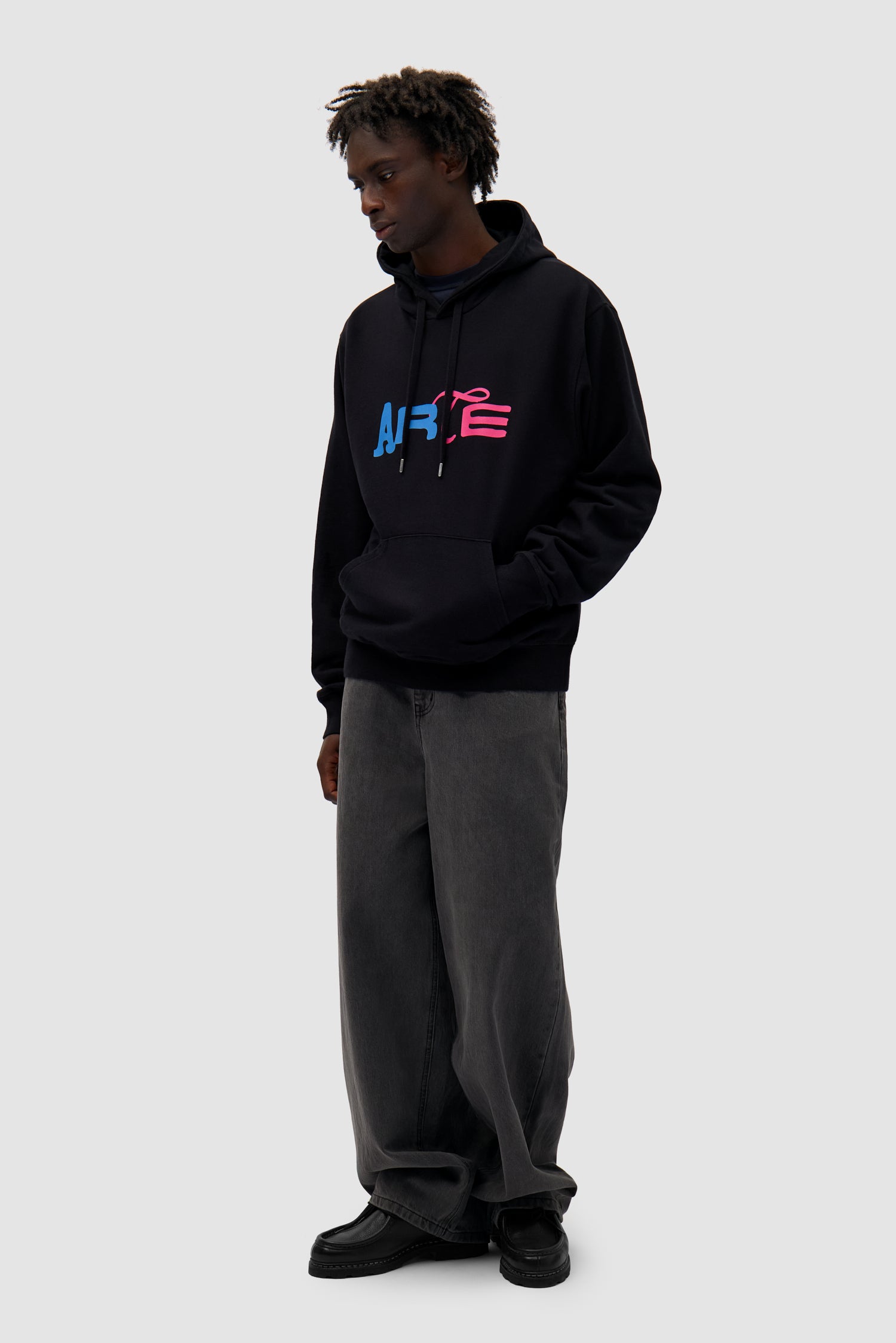 Duo Logo Hoodie in Black worn by a model, full-body back view